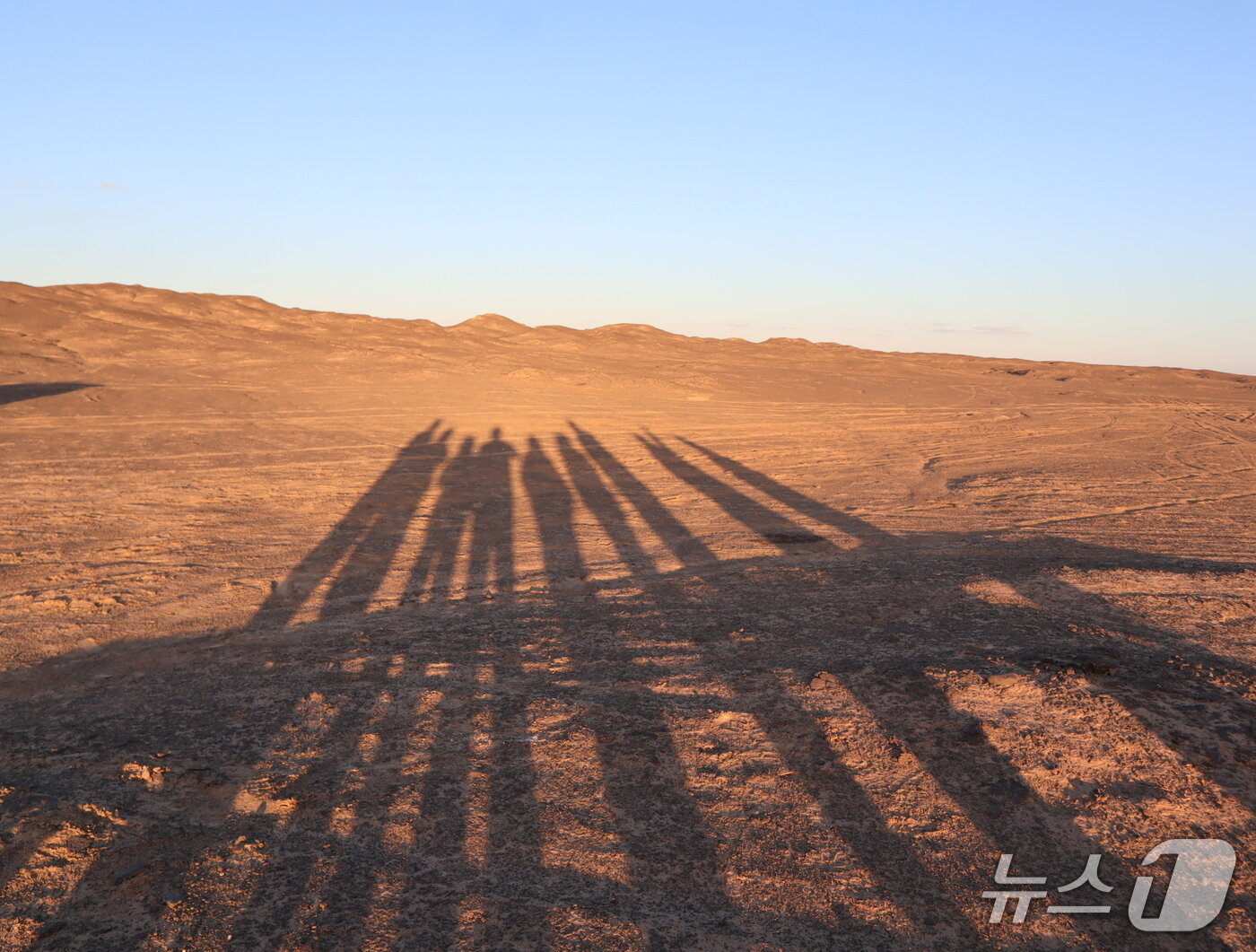 본문 이미지 - 저물어가는 태양 속에 방문자들의 그림자가 길게 드리워진 흑사막의 풍경. ⓒ 뉴스1 김정한 기자