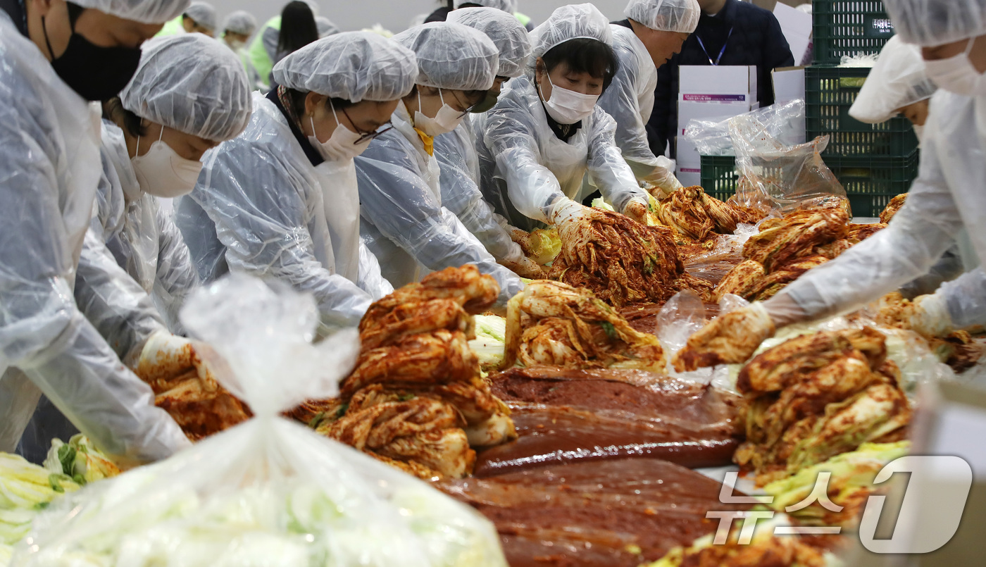 (부산=뉴스1) 윤일지 기자 = 19일 부산 해운대구 벡스코 제2전시장에서 열린 '2025 사랑의 김치나눔 한마당'에서 자원봉사자들이 김장을 하고 있다.후원 기업·기관 임직원, 자 …