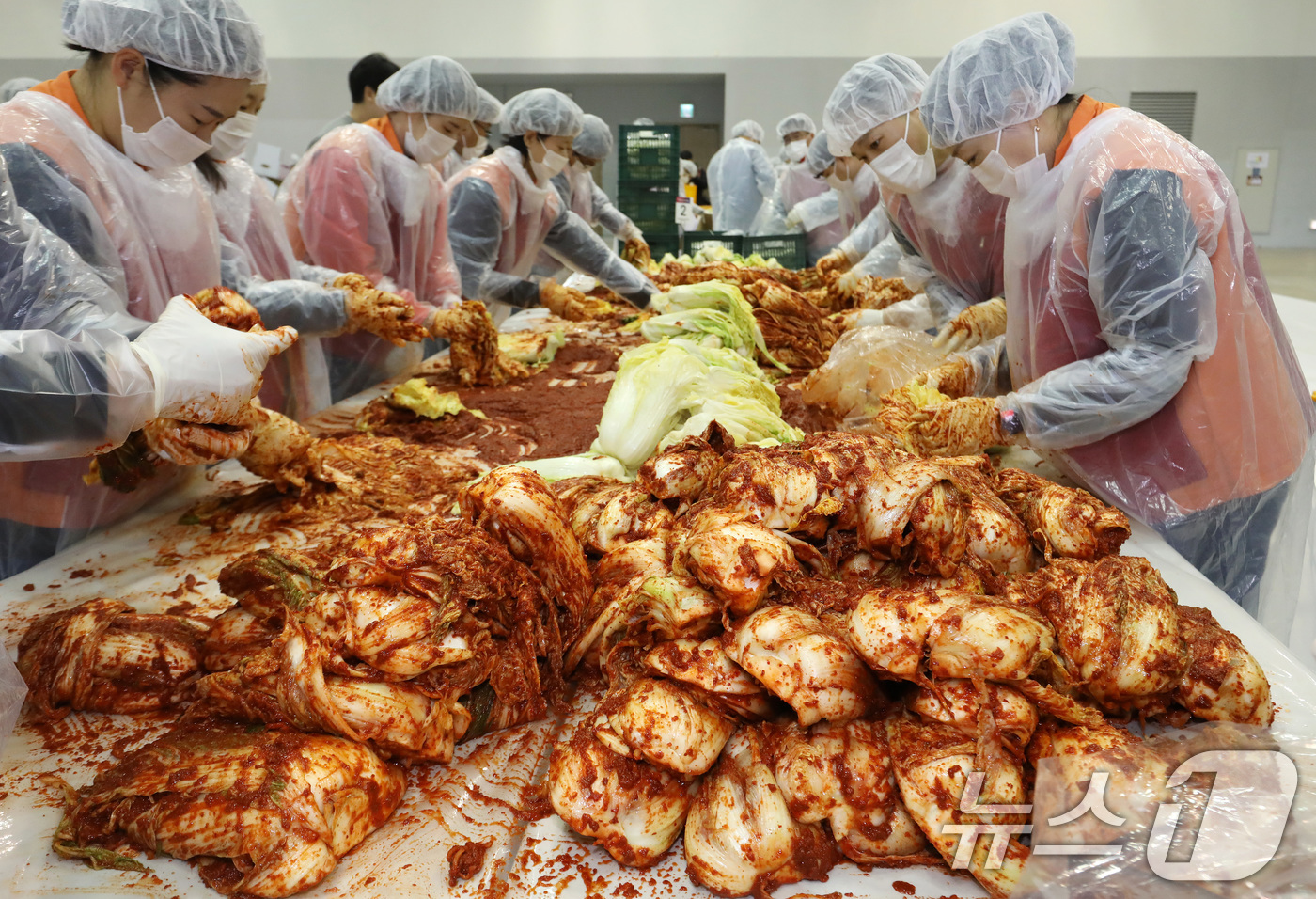 (부산=뉴스1) 윤일지 기자 = 19일 부산 해운대구 벡스코 제2전시장에서 열린 '2025 사랑의 김치나눔 한마당'에서 자원봉사자들이 김장을 하고 있다.후원 기업·기관 임직원, 자 …