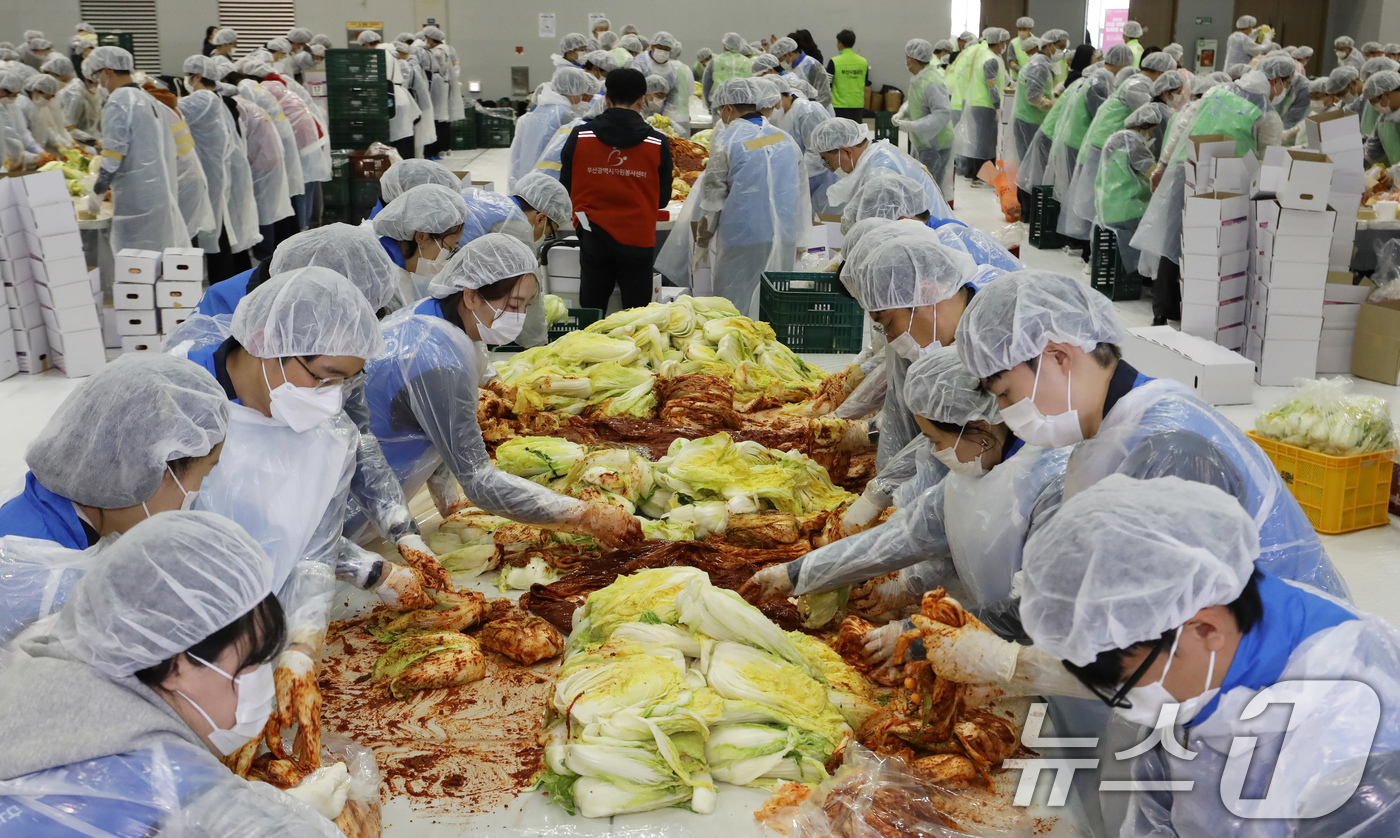 (부산=뉴스1) 윤일지 기자 = 19일 부산 해운대구 벡스코 제2전시장에서 열린 '2025 사랑의 김치나눔 한마당'에서 자원봉사자들이 김장을 하고 있다.후원 기업·기관 임직원, 자 …