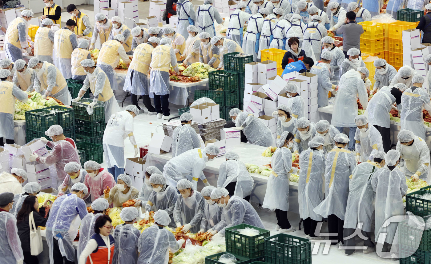 (부산=뉴스1) 윤일지 기자 = 19일 부산 해운대구 벡스코 제2전시장에서 열린 '2025 사랑의 김치나눔 한마당'에서 자원봉사자들이 김장을 하고 있다.후원 기업·기관 임직원, 자 …