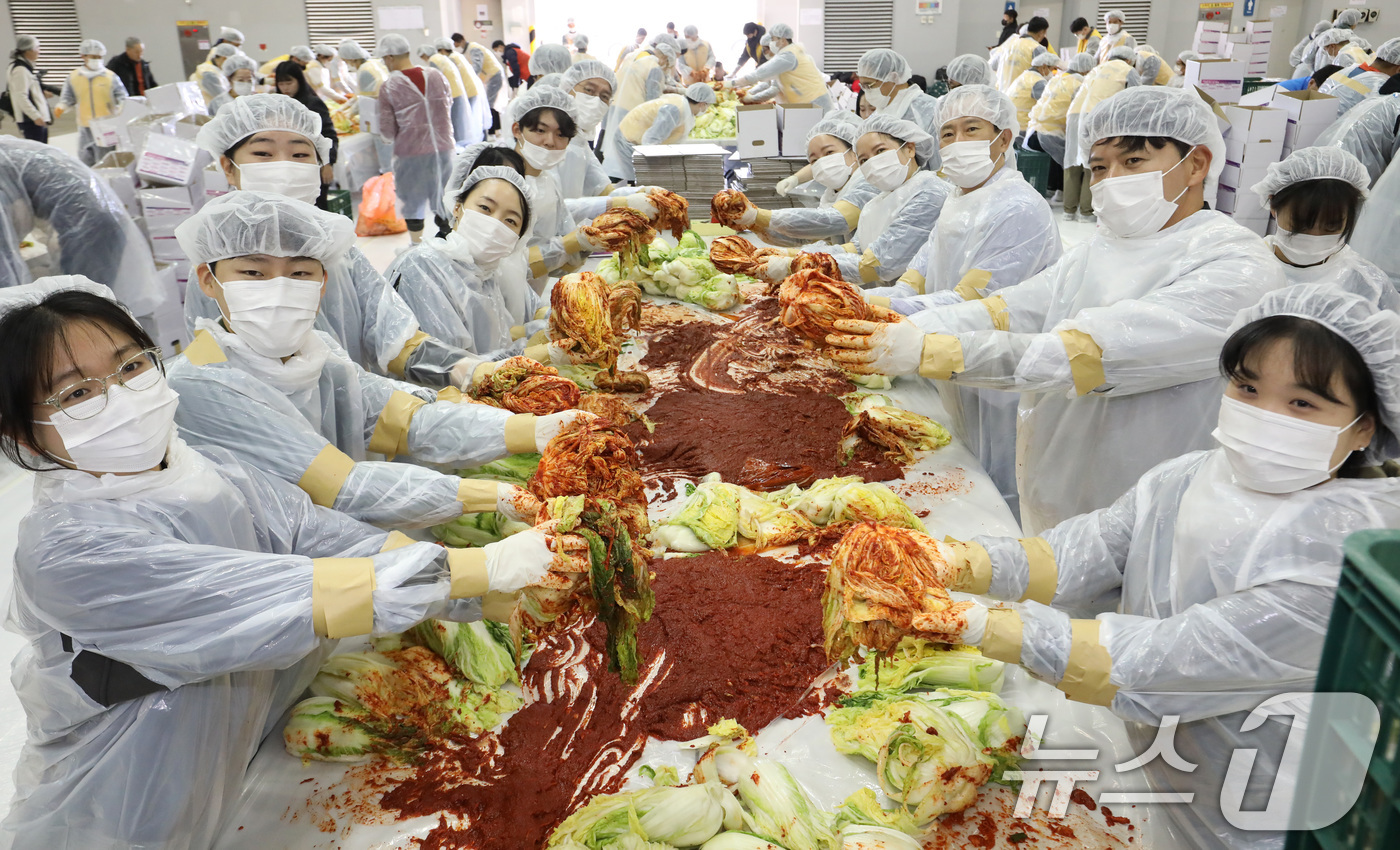 (부산=뉴스1) 윤일지 기자 = 19일 부산 해운대구 벡스코 제2전시장에서 열린 '2025 사랑의 김치나눔 한마당'에서 자원봉사자들이 김장을 하고 있다.후원 기업·기관 임직원, 자 …