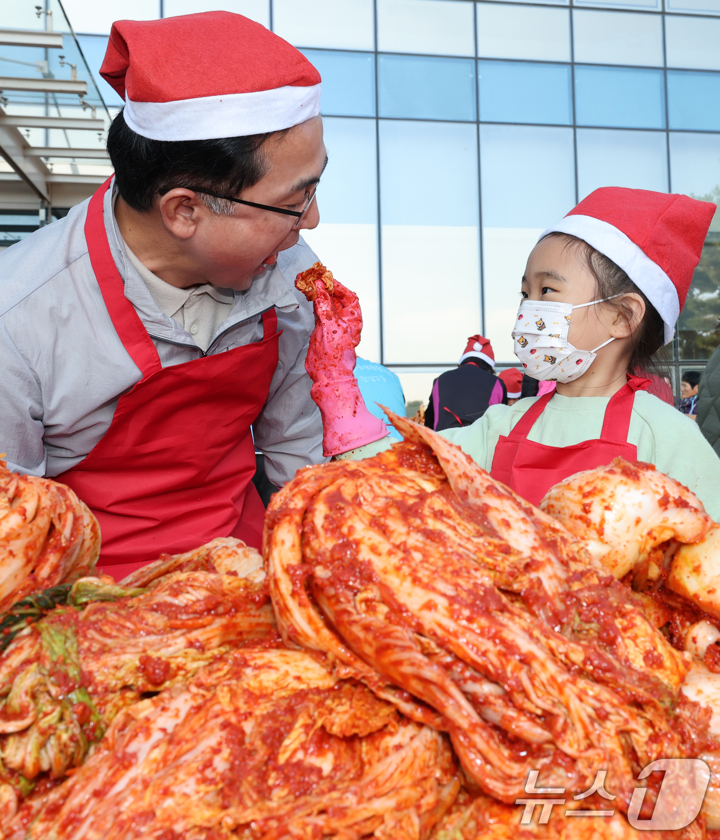 (대전=뉴스1) 김기태 기자 = 19일 대전 동구청에서 열린 천사의손길 김장나눔대축제에서 박희조 동구청장이 봉사자들과 함께 김장을 하던 중 어린이가 담근 김치를 맛보고 있다.이날 …