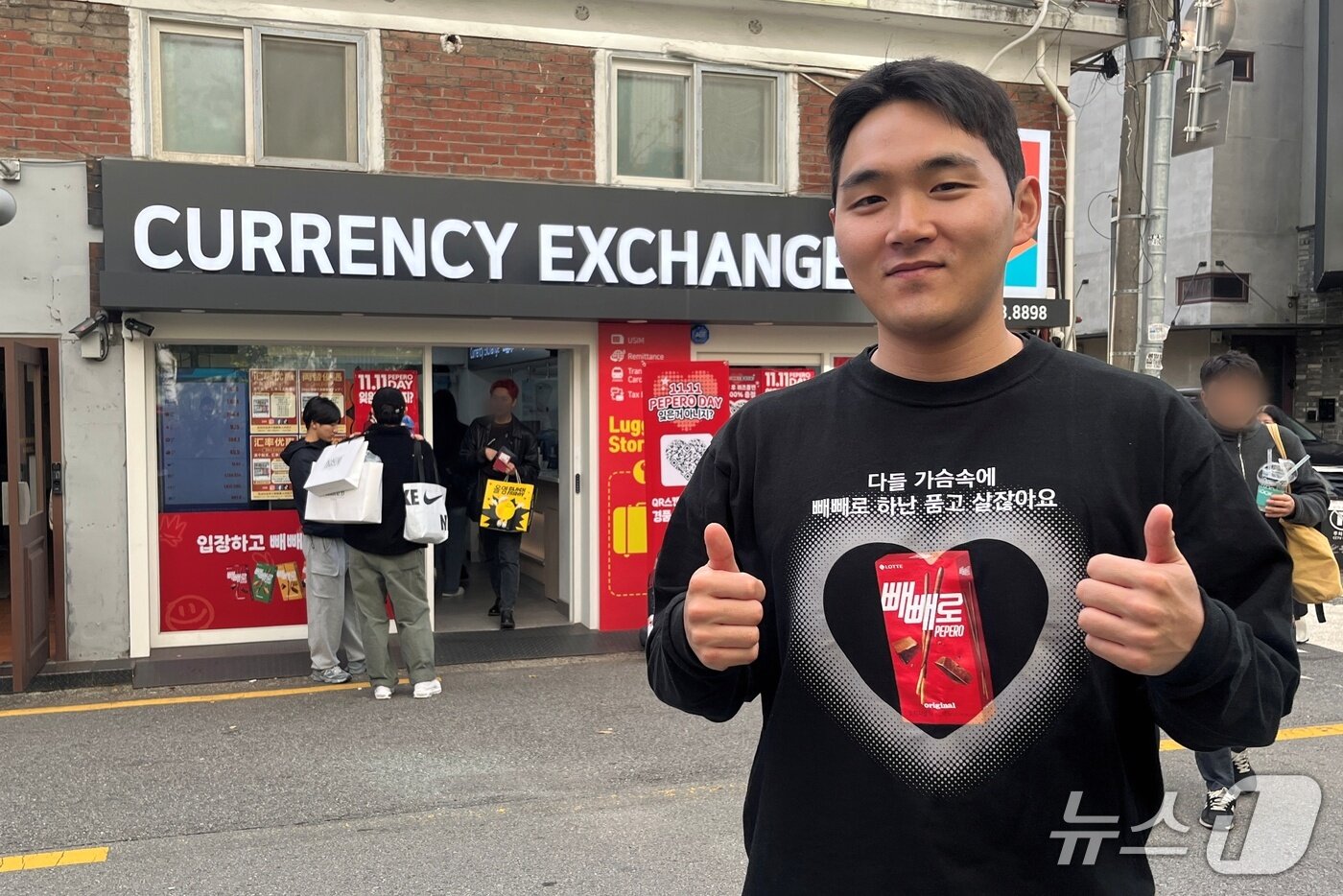 본문 이미지 - 빼빼로 접수처 직원인 김재희 매니저가 직접 제작한 빼빼로 홍보 티셔츠를 입고 포즈를 취하고 있다. / 뉴스1 박혜연 기자 ⓒ 뉴스1