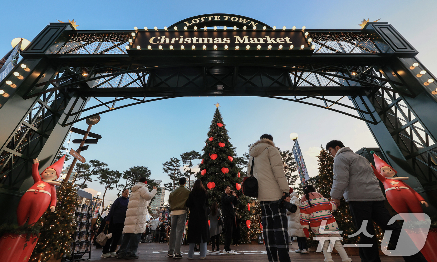 (서울=뉴스1) 이호윤 기자 = 20일 서울 송파구 롯데월드타워 월드파크 잔디광장에서 열린 '롯데타운 크리스마스 마켓'을 찾은 시민들과 관광객들이 입장하고 있다. 2025.11.2 …