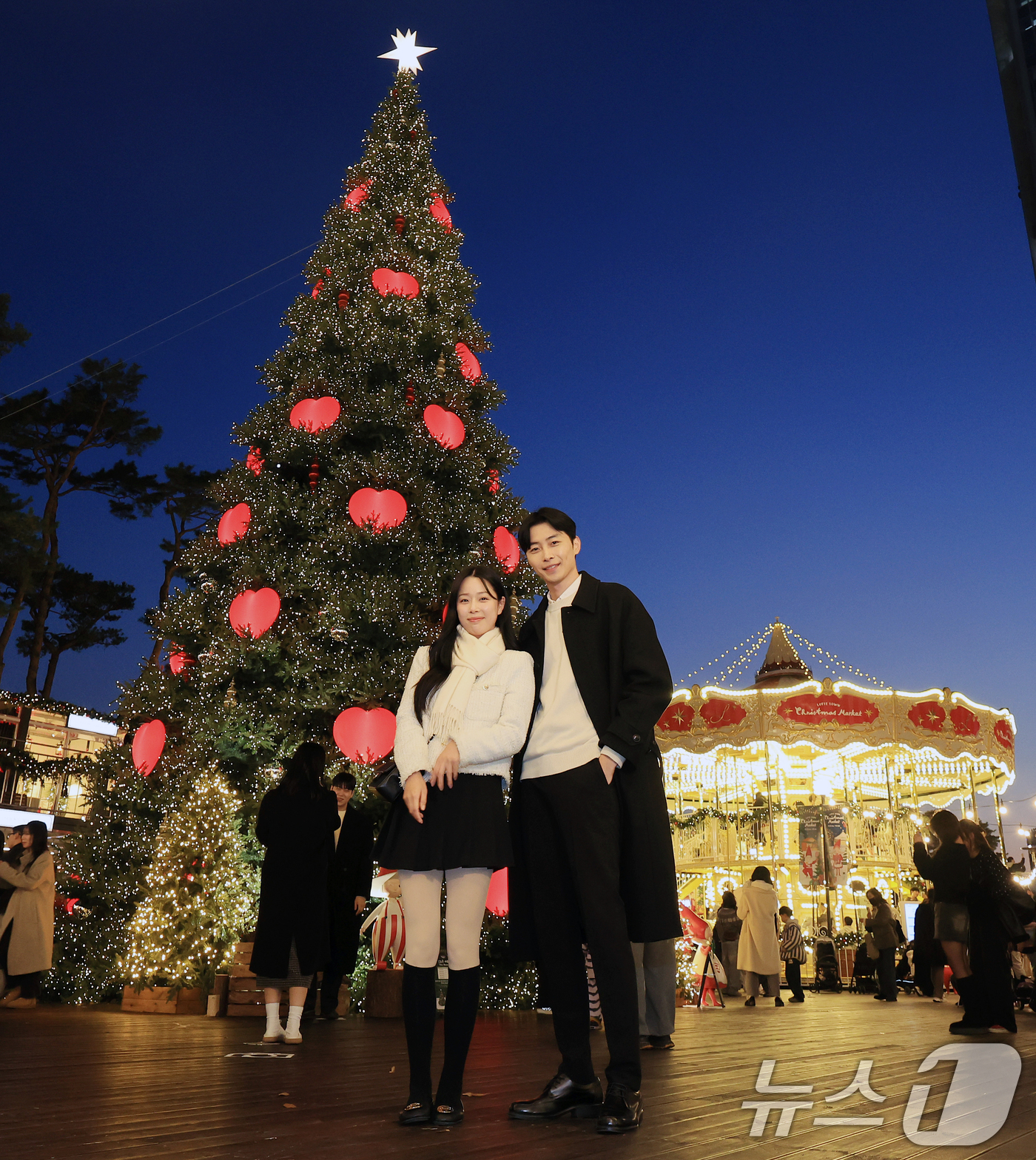 (서울=뉴스1) 이호윤 기자 = 20일 서울 송파구 롯데월드타워 월드파크 잔디광장에서 열린 '롯데타운 크리스마스 마켓'에서 모델들이 행사를 홍보하고 있다. 2025.11.20/뉴스 …