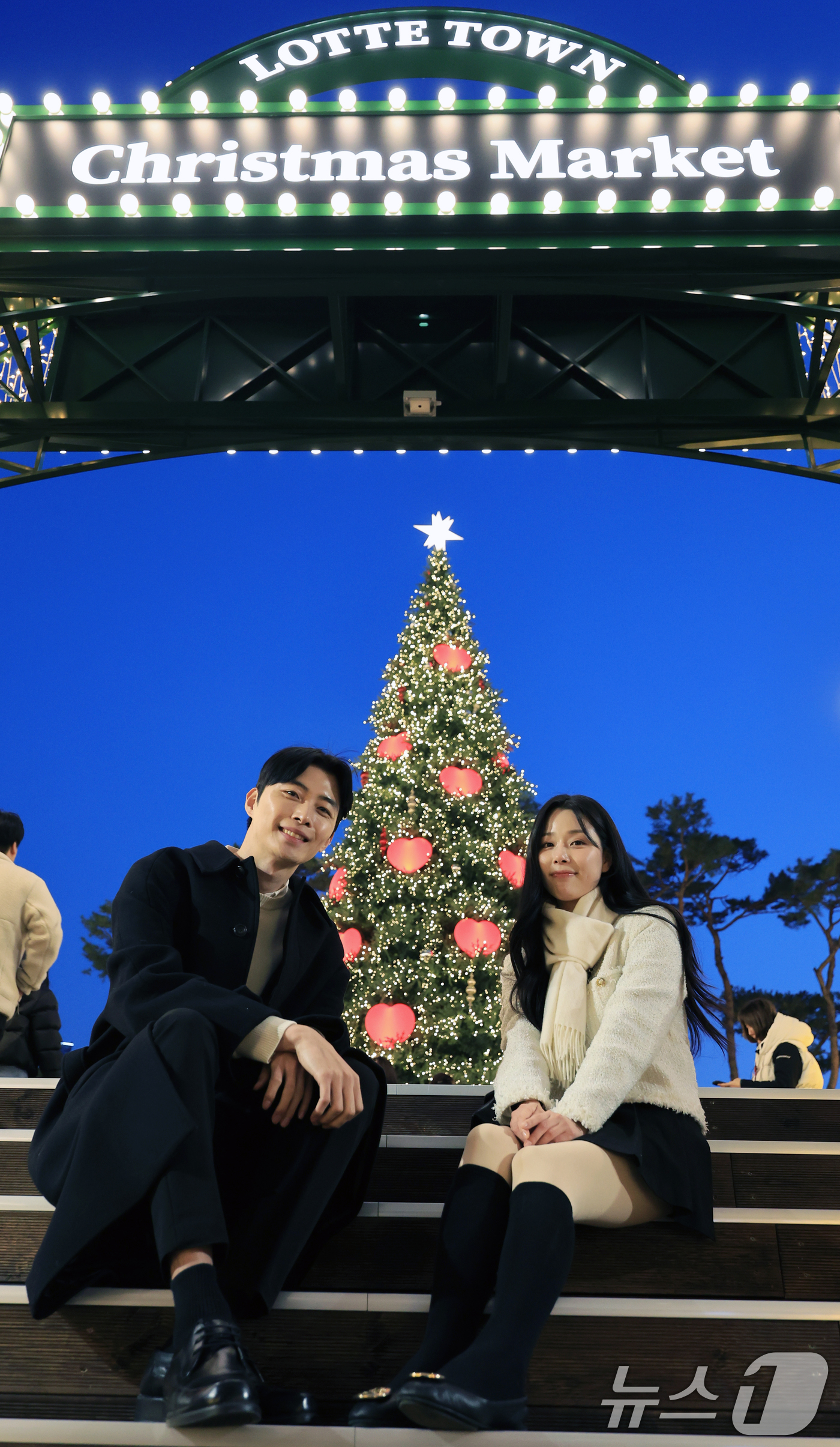 (서울=뉴스1) 이호윤 기자 = 20일 서울 송파구 롯데월드타워 월드파크 잔디광장에서 열린 '롯데타운 크리스마스 마켓'에서 모델들이 행사를 홍보하고 있다. 2025.11.20/뉴스 …