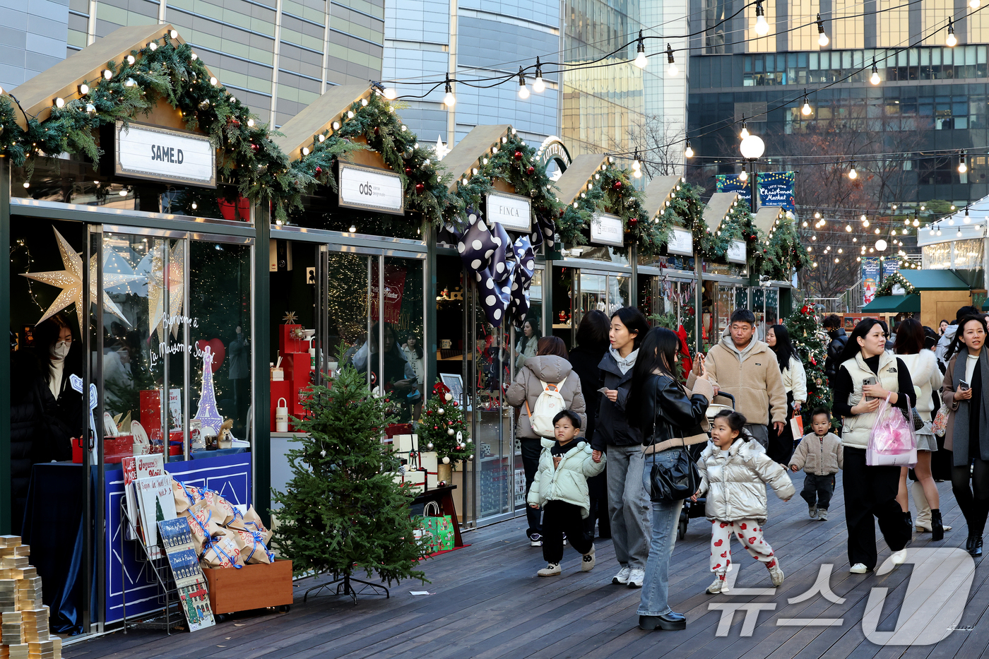 (서울=뉴스1) 이호윤 기자 = 20일 서울 송파구 롯데월드타워 월드파크 잔디광장에서 열린 '롯데타운 크리스마스 마켓'을 찾은 시민들이 부스를 둘러보고 있다. 2025.11.20/ …