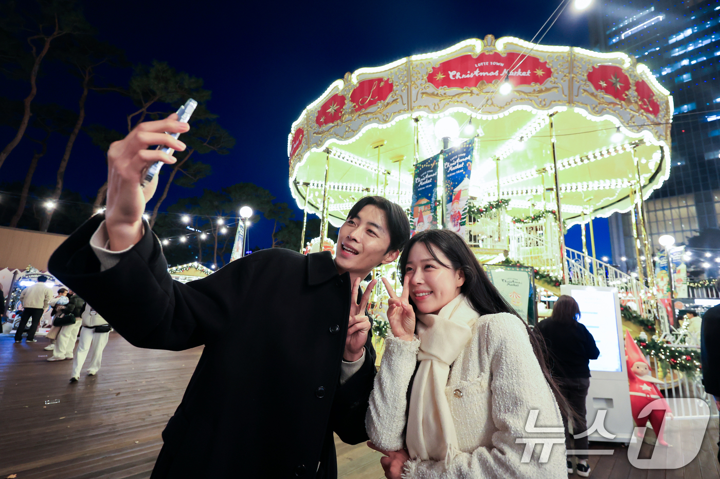 (서울=뉴스1) 이호윤 기자 = 20일 서울 송파구 롯데월드타워 월드파크 잔디광장에서 열린 '롯데타운 크리스마스 마켓'에서 모델들이 행사를 홍보하고 있다. 2025.11.20/뉴스 …