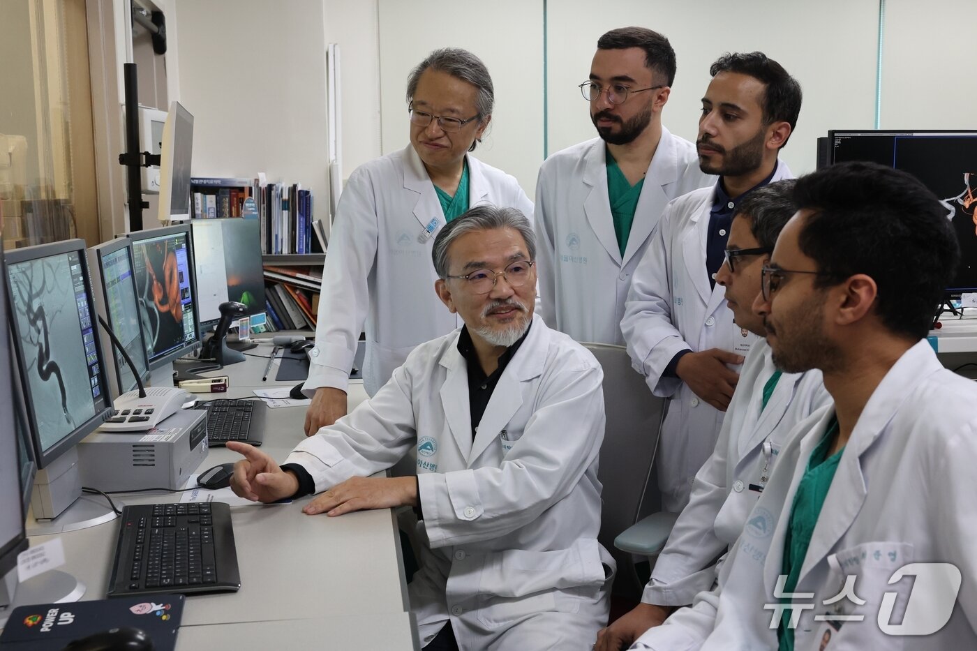 본문 이미지 - 서울아산병원 의료진이 전날 혈관조영실에서 사우디아라비아 의학자들에게 뇌혈관 조영술 영상에서 보이는 뇌동맥류의 치료 방침을 교육하고 있다. &#40;왼쪽부터&#41;영상의학과 이덕희·최충곤 교수, 사우디아라비아 아흐메드 박시·무한나드 알라나지·알리 캄리·압둘라 알힌디 전문의.&#40;서울아산병원 제공&#41; 2025.11.20/뉴스1