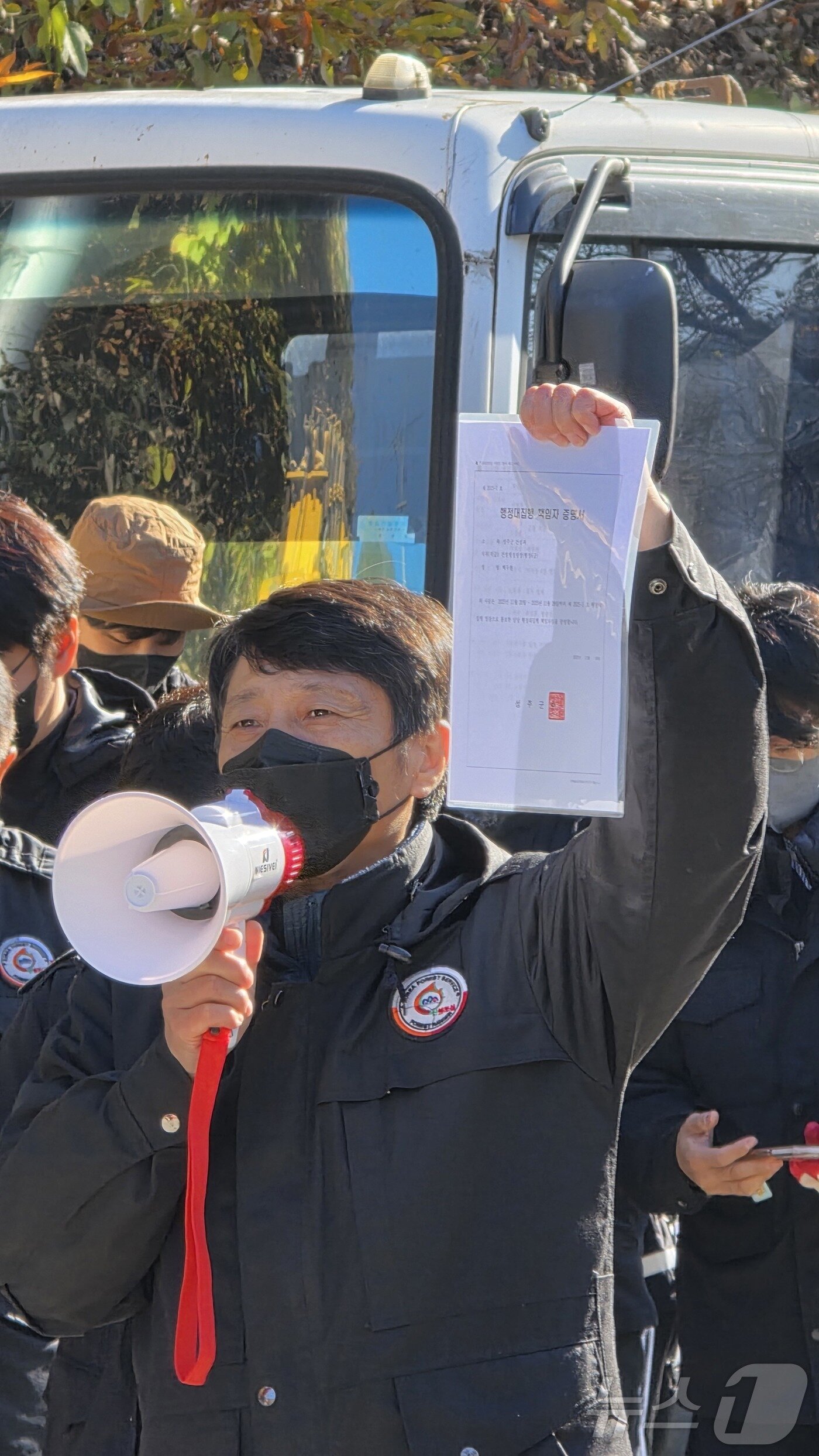본문 이미지 - 21일 오전 경북 성주군에 있는 사드&#40;THAAD·고고도 미사일 방어체계&#41; 기지 입구 진밭교 앞에서 성주군 공무원이 서류를 들어보이며 행정대집행을 알리고 있다. 2025.11.21/뉴스1 ⓒ News1 정우용 기자