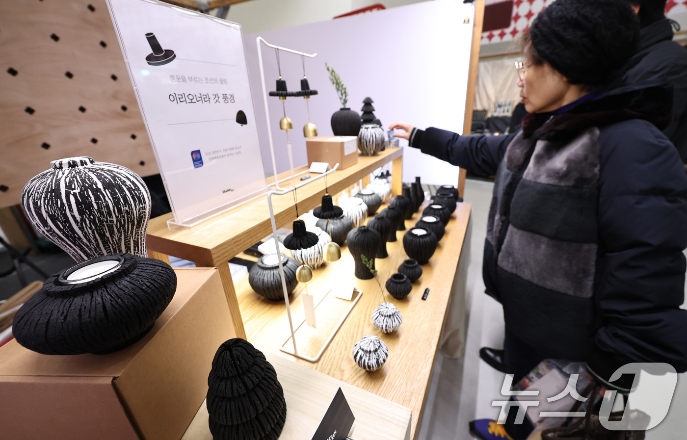 (서울=뉴스1) 구윤성 기자 = 21일 서울 동대문디자인플라자(DDP)에서 열린 '2025 대한민국 관광기념품 박람회'에서 참관객이 숯으로 만든 백자·청자 모양의 오브제를 살펴보고 …