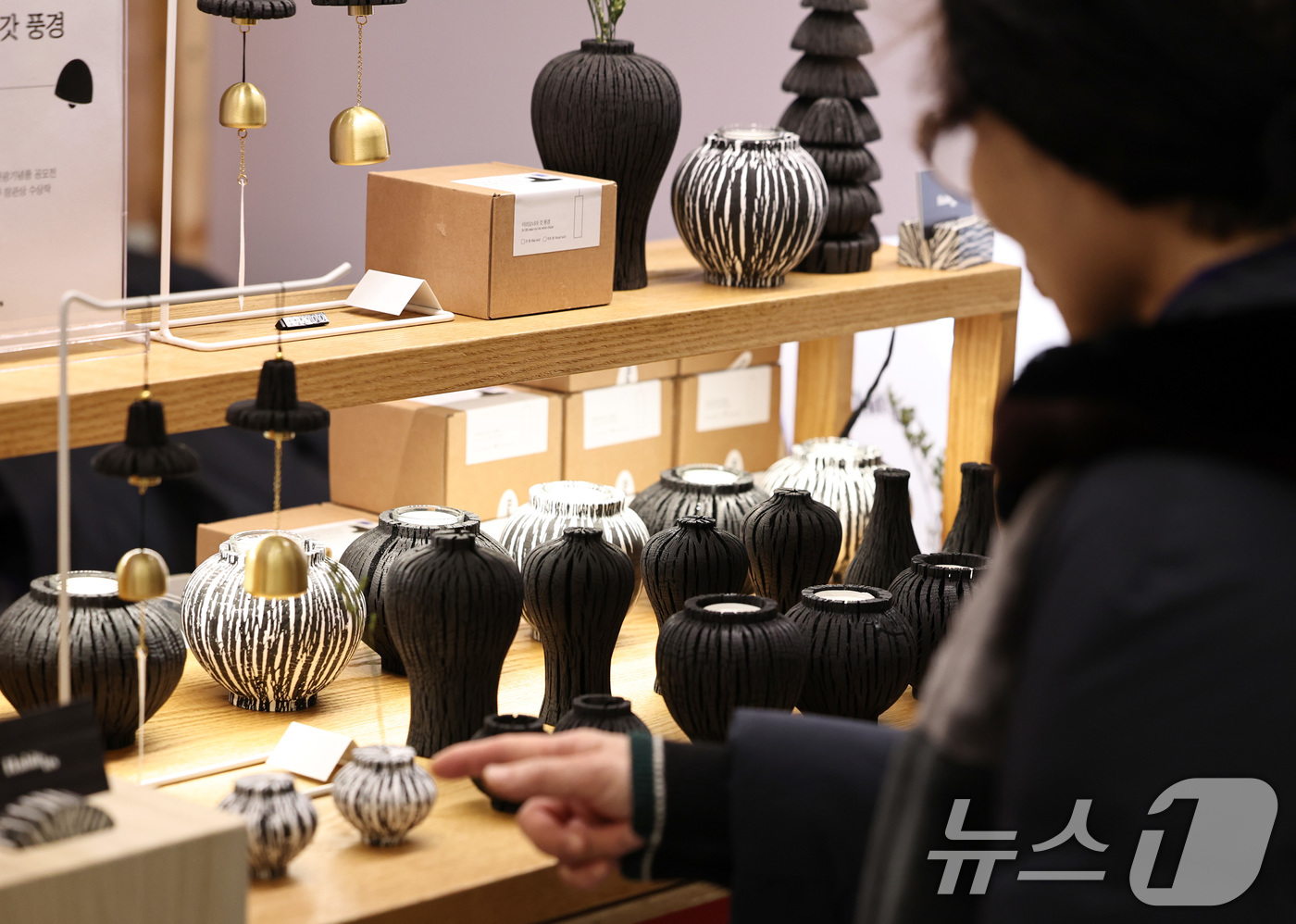 (서울=뉴스1) 구윤성 기자 = 21일 서울 동대문디자인플라자(DDP)에서 열린 '2025 대한민국 관광기념품 박람회'에서 참관객이 숯으로 만든 백자·청자 모양의 오브제를 살펴보고 …