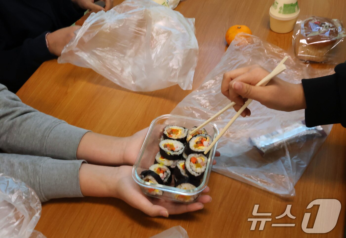 본문 이미지 - 21일 학교비정규직 노조의 파업으로 인해 광주 북구 문흥동 문흥중학교에서 학생들이 대체식인 빵을 먹고 있다. 사진은 한 학생이 싸온 김밥을 친구들에게 나눠주는 모습. ⓒ News1 박지현 기자