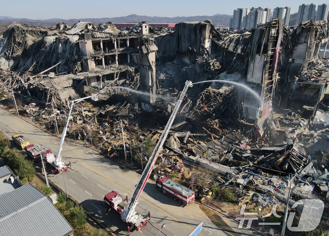 (천안=뉴스1) 김기태 기자 = 이랜드패션 물류센터 화재 현장감식이 실시된 21일 충남 천안시 동남구 풍세면 이랜드유통 천안 물류센터에서 소방차량으로 방수하고 있다. 2025.11 …