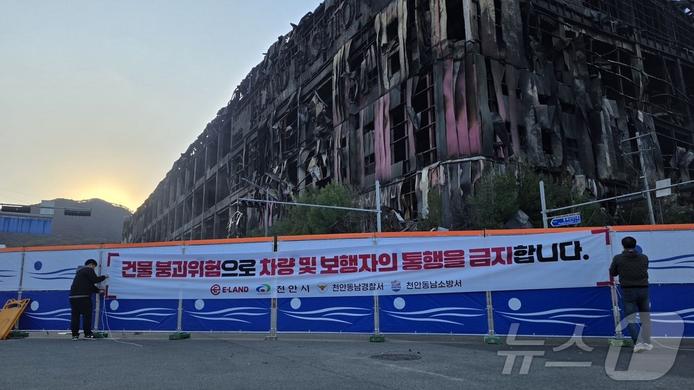 (천안=뉴스1) 이시우 기자 = 이랜드 물류센터 화재 진압이 완료된 21일 충남 천안 동남구 풍세면 이랜드 물류센터 현장 도로에 출입 통제를 위한 안전 펜스가 설치되고 있다.  2 …