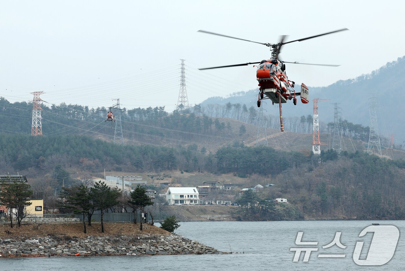 본문 이미지 - 23일 강원 양양군 서면 서림리 방태산 인근에 산림청 산불 진화 헬기들이 급수를 위해 고도를 낮추고 있다. 2025.11.23/뉴스1 ⓒ News1 이호윤 기자