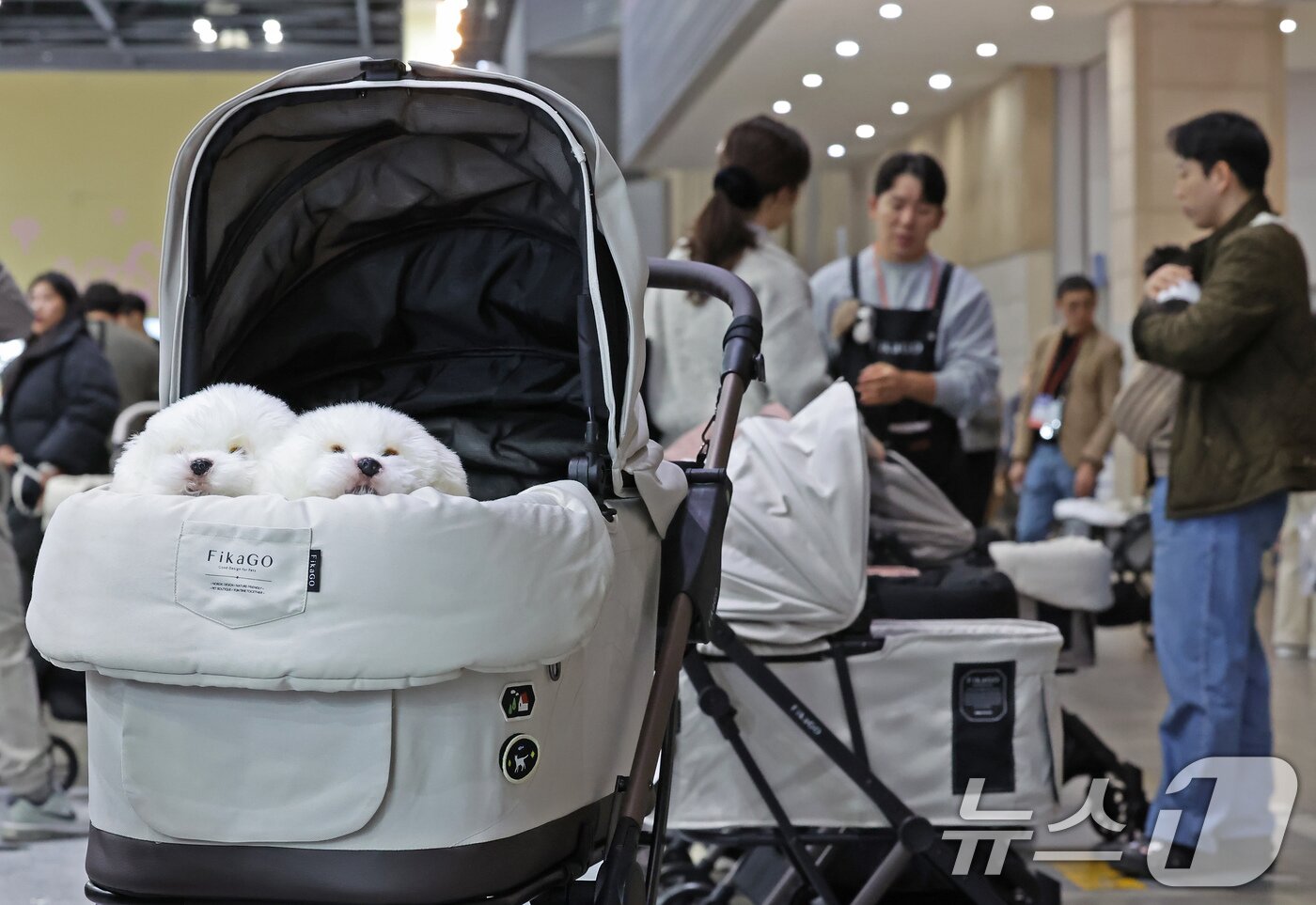 본문 이미지 - 23일 경기 고양시 킨텍스에서 진행중인 '2025 메가주 일산'을 찾은 관람객들이 애견용 유모차를 살펴보고 있다. 2025.11.23/뉴스1 ⓒ News1 장수영 기자