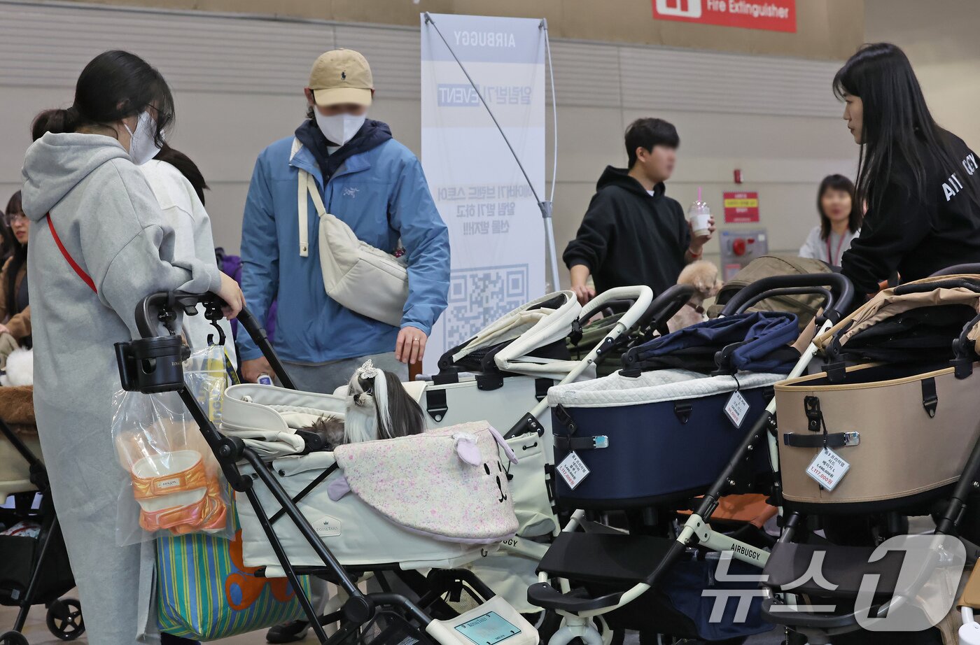 본문 이미지 - 23일 경기 고양시 킨텍스에서 진행중인 '2025 메가주 일산'을 찾은 관람객들이 애견용 유모차를 살펴보고 있다. 2025.11.23/뉴스1 ⓒ News1 장수영 기자