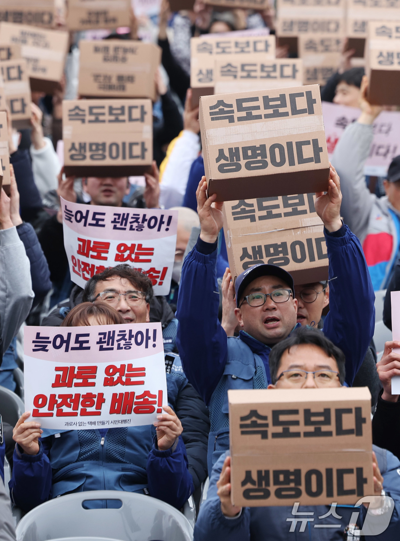 (서울=뉴스1) 박지혜 기자 = 택배노동자들이 23일 서울 광화문 동십자각 앞에서 열린 '과로사 없는 택배 만들기 시민대행진'에 앞서 구호를 외치고 있다.새벽배송을 둘러싼 논쟁은 …