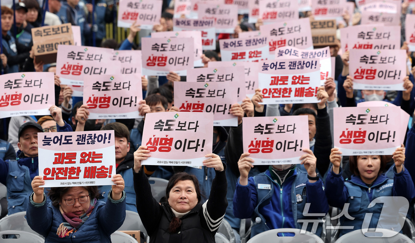 (서울=뉴스1) 박지혜 기자 = 택배노동자들이 23일 서울 광화문 동십자각 앞에서 열린 '과로사 없는 택배 만들기 시민대행진'에 앞서 구호를 외치고 있다.새벽배송을 둘러싼 논쟁은 …