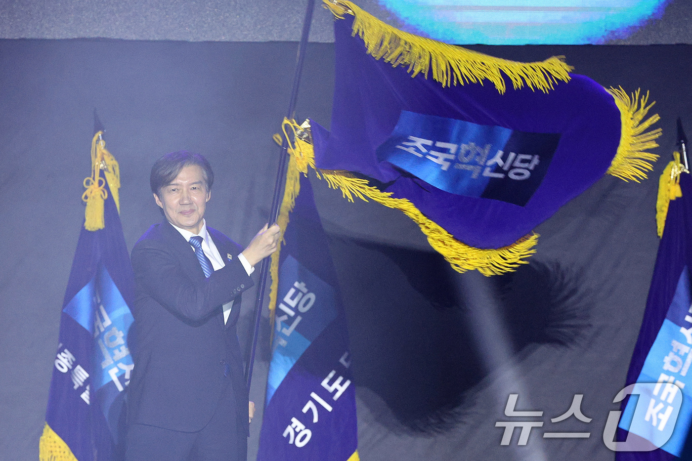 (청주=뉴스1) 신웅수 기자 = 조국 신임 조국혁신당 당대표가 23일 충북 청주시 오스코에서 열린 조국혁신당 전국당원대회에서 당기를 들고 당원들에게 인사하고 있다. 2025.11. …