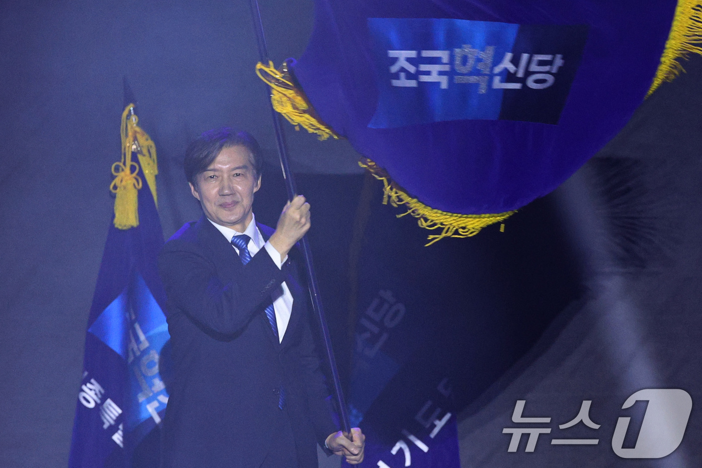 (청주=뉴스1) 신웅수 기자 = 조국 신임 조국혁신당 당대표가 23일 충북 청주시 오스코에서 열린 조국혁신당 전국당원대회에서 당기를 들고 당원들에게 인사하고 있다. 2025.11. …