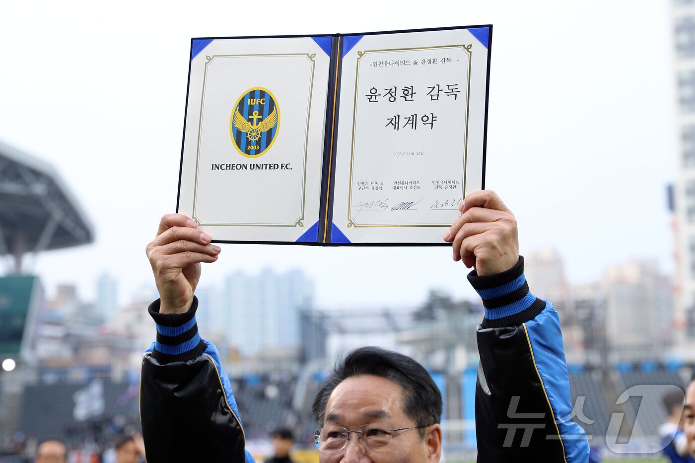 본문 이미지 - 인천유나이티드 구단주인 유정복 인천시장이 23일 오후 인천시 중구 도원동 인천축구전용경기장에서 열린 하나은행 K리그2 2025 39라운드 인천유나이티드와 충북청주의 경기 종료 후 윤정환 감독, 조건도 인천유나이티드 대표와 재계약 서명한 서명문을 들어 보이고 있다. 2025.11.23/뉴스1 ⓒ News1 박정호 기자