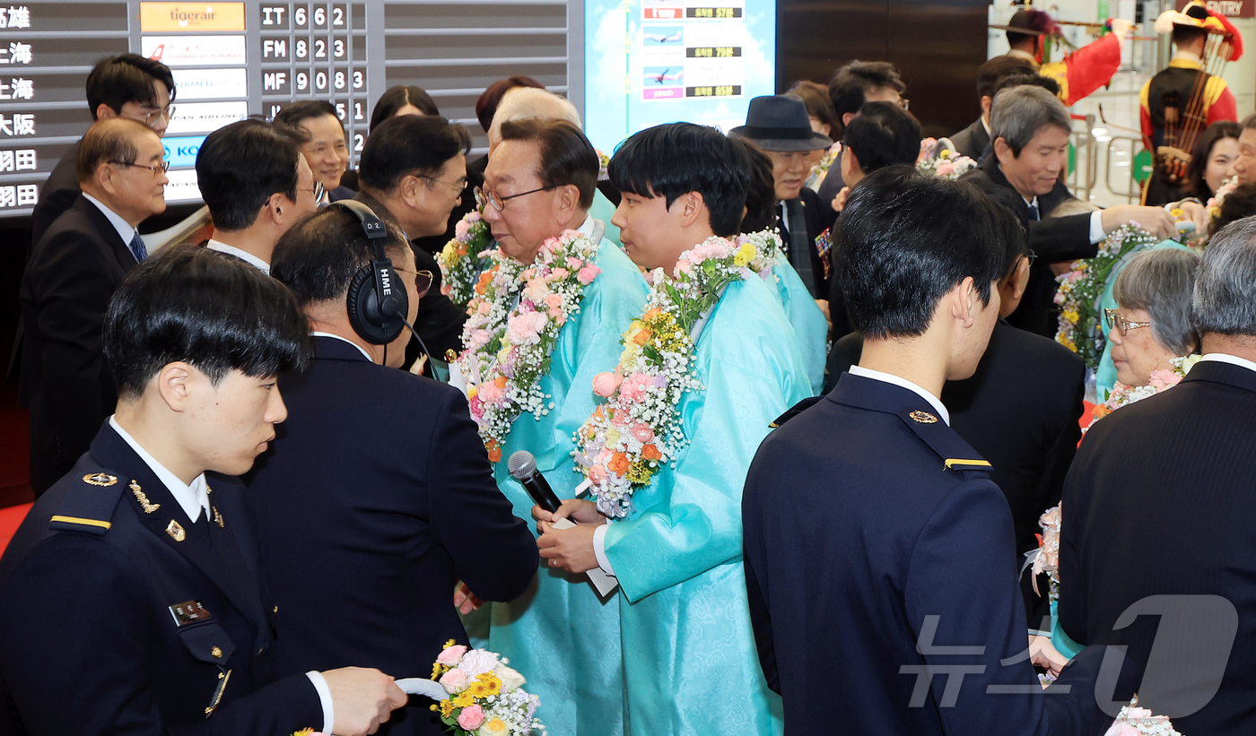 (서울=뉴스1) 김진환 기자 = 23일 오후 서울 강서구 김포공항 국제선 청사 입국장에서 열린 '대한민국임시정부 요인 환국 재현' 행사에서 임시정부 요인 후손들이 꽃목걸이를 받고 …