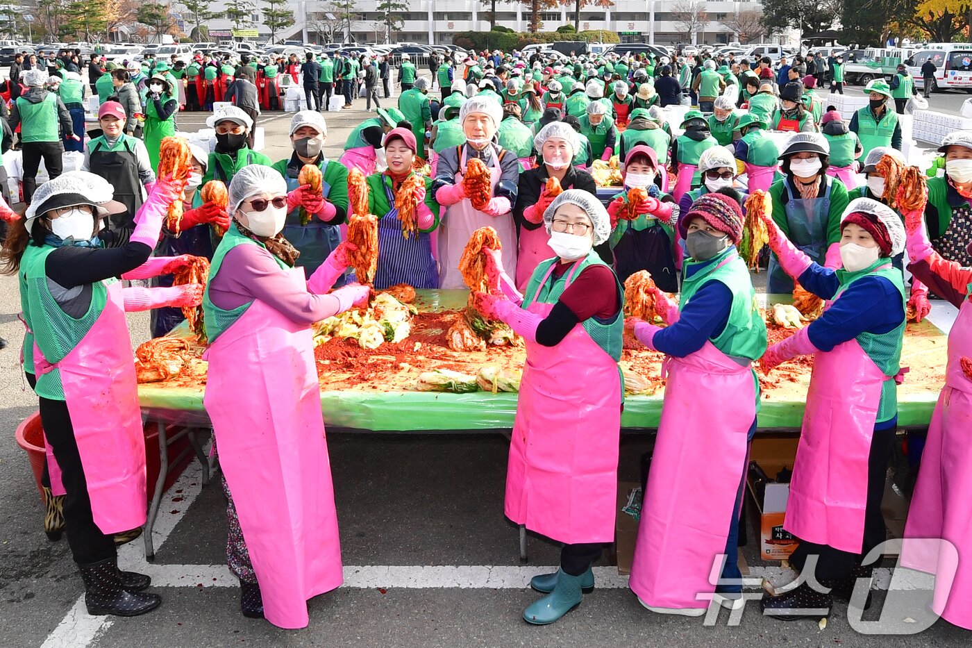 본문 이미지 - 이강덕 경북 포항시장과 부인 최혜련 여사가 24일 포항실내체육관 앞에서 열린 2025 포항시새마을회 사랑의김장담그기 행사에서 새마을회원들과 함께 배추를 버무리고 있다. 2025.11.24/뉴스1 ⓒ News1 최창호 기자