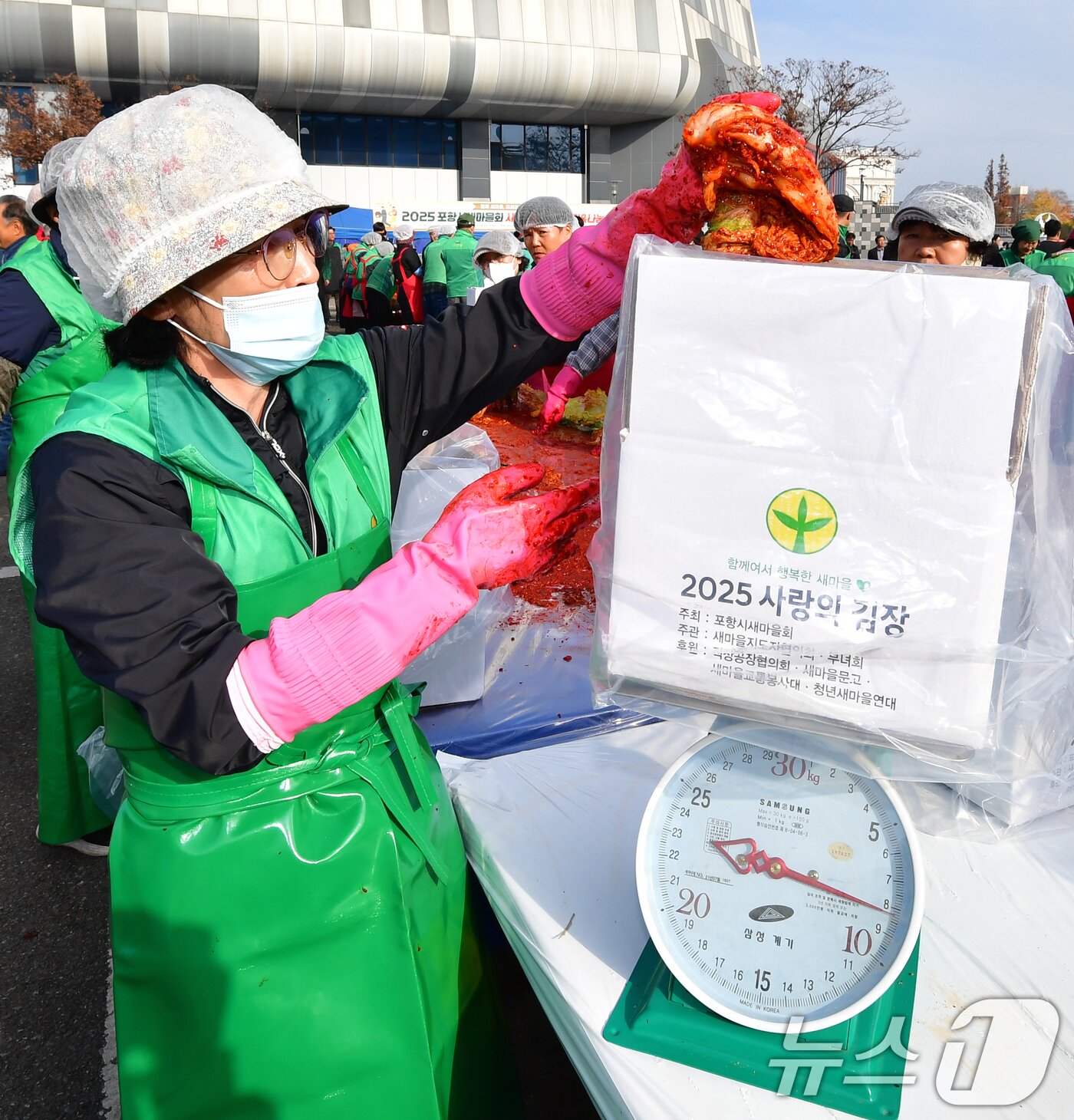 본문 이미지 - 24일 포항실내체육관 앞에서 열린 2025 포항시새마을회 사랑의김장담그기 행사에서 새마을회원들이 버무린 배추를 박스에 담고 있다. 2025.11.24/뉴스1 ⓒ News1 최창호 기자