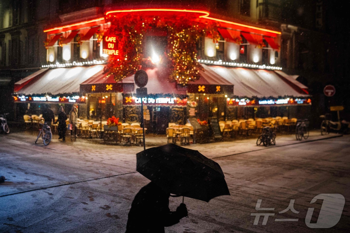 (파리 AFP=뉴스1) 이정환 기자 = 23일(현지시간) 새벽, 파리 중심부에 폭설이 내리는 가운데 한 남성이 우산으로 자신을 보호하고 있다. 프랑스 기상청 메테오프랑스는 이번 시 …