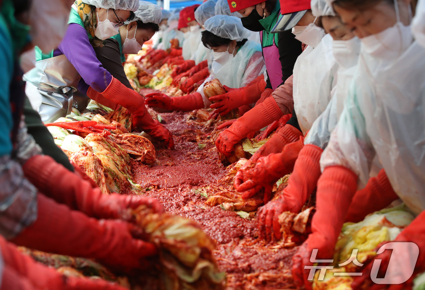 (대구=뉴스1) 공정식 기자 = 25일 오전 대구 수성구청에서 열린 '2025년 사랑의 김장 담그기' 행사에 참여한 수성구새마을회 등 자원봉사자들이 양념을 정성껏 버무리고 있다.이 …