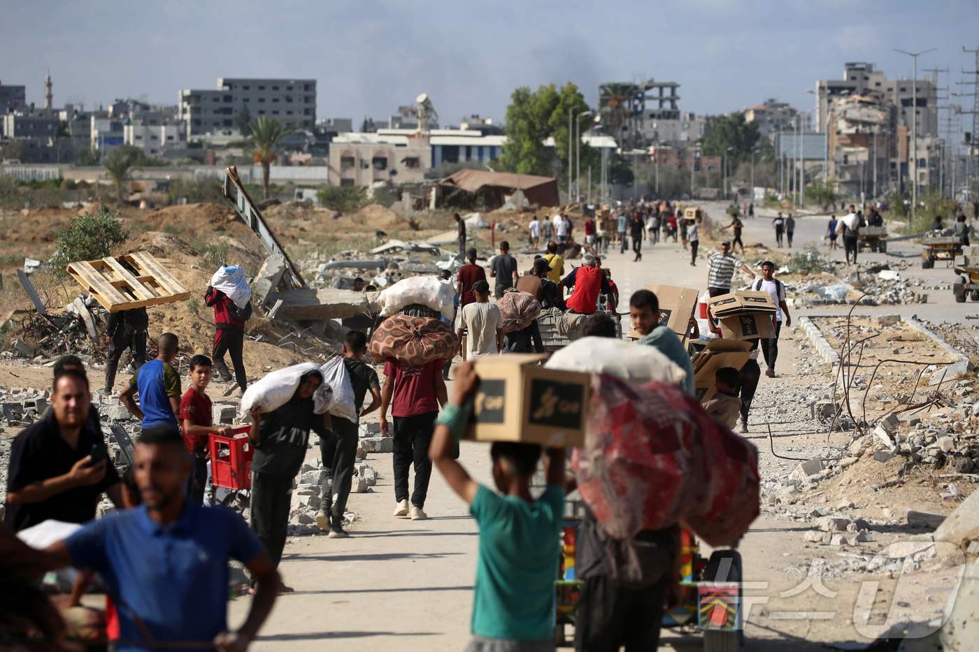 (누세이라트 AFP=뉴스1) 이창규 기자 = 팔레스타인 주민들이 10월 5일 가자 인도주의 재단(GHF)가 운영하는 배급소에서 돌아오고 있다. 2025.10.5./뉴스1ⓒ AFP= …