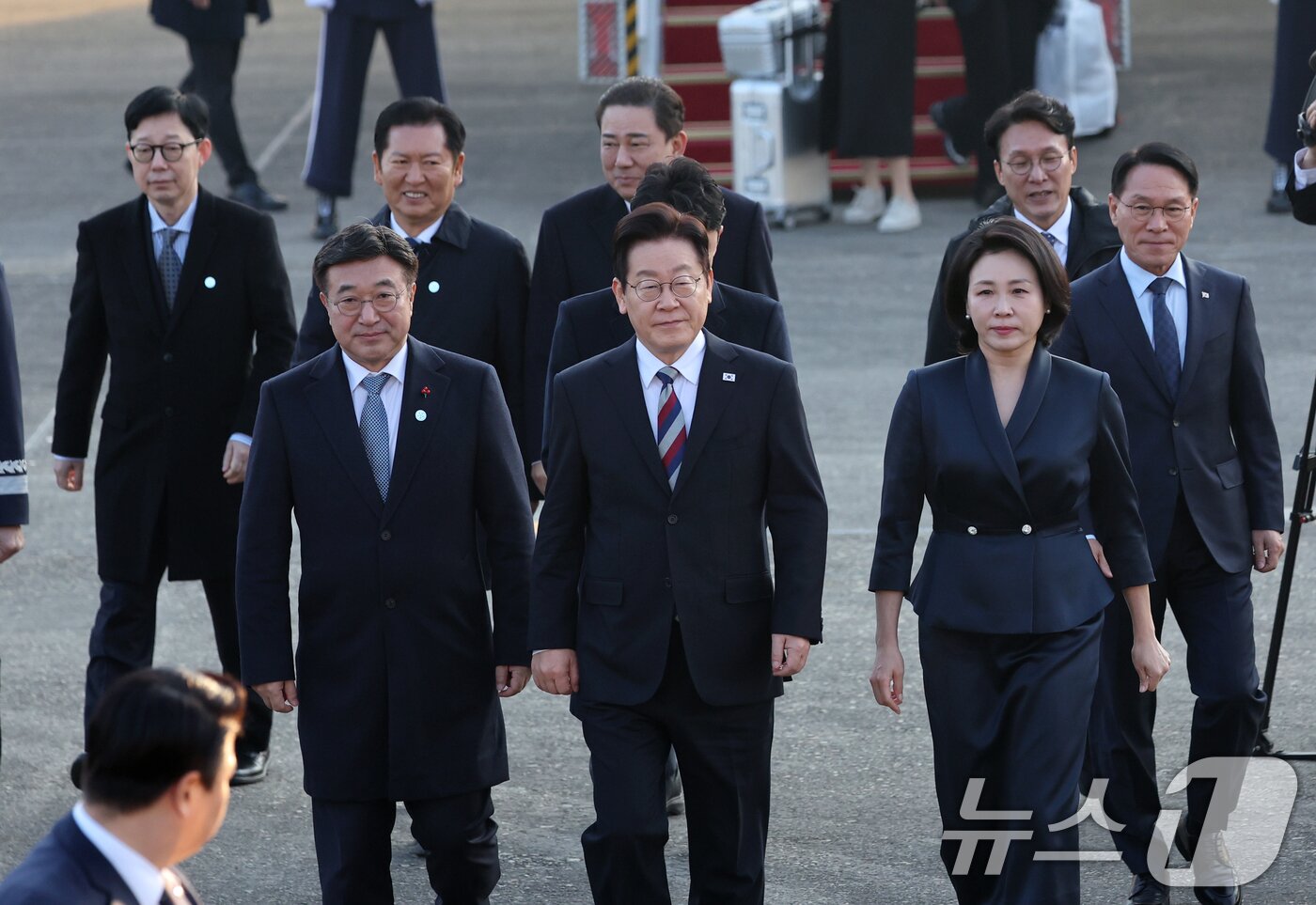 본문 이미지 - 아프리카·중동 4개국 순방 일정을 마무리한 이재명 대통령과 김혜경 여사가 26일 오전 경기도 성남시 서울공항을 통해 귀국, 환영인사들과 함께 이동하고 있다. 2025.11.26/뉴스1 ⓒ News1 황기선 기자