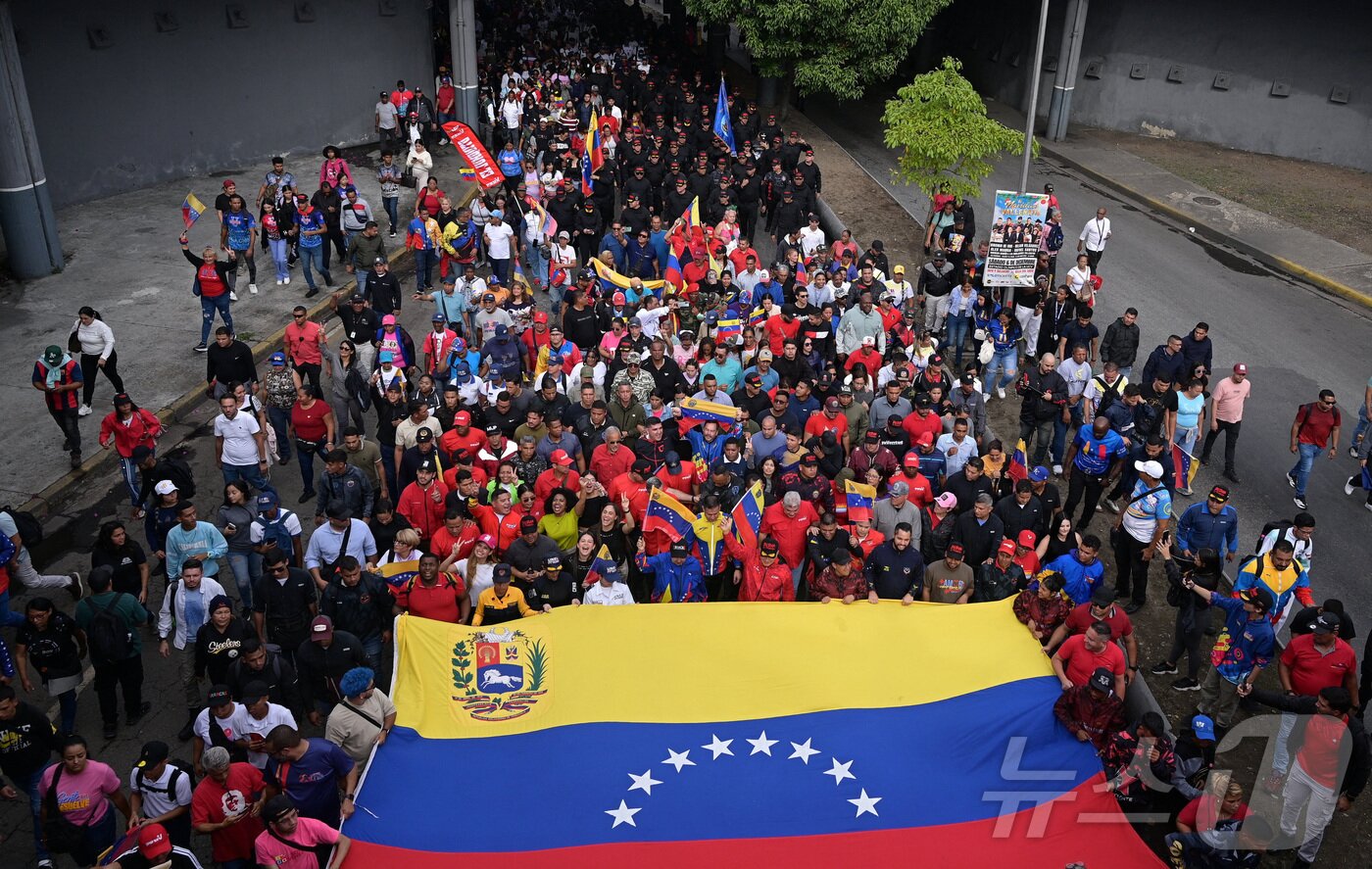 본문 이미지 - 2025년 11월 25일 베네수엘라 카라카스에서 미국이 베네수엘라에 대한 군사 조치를 확대할 가능성에 반대하는 집회에 참가한 사람들이 베네수엘라 국기를 크게 흔들고 있다. 2025.11.25. ⓒ 로이터=뉴스1 ⓒ News1 이정환 기자