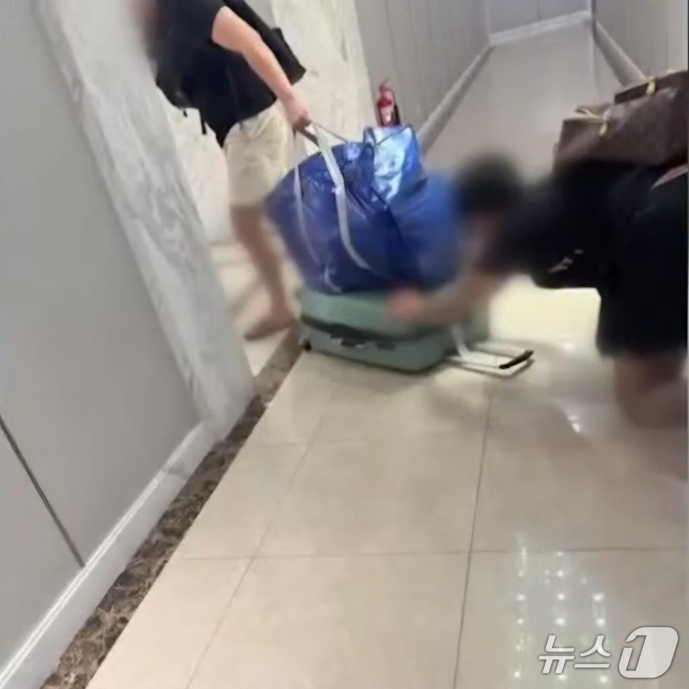 본문 이미지 - A 씨를 살해하고 파란색 가방에 시신을 넣어 옮기고 있는 B 씨와 C 씨.(베트남 플러스 제공. 재판매 및 DB 금지)2025.11.26/뉴스1