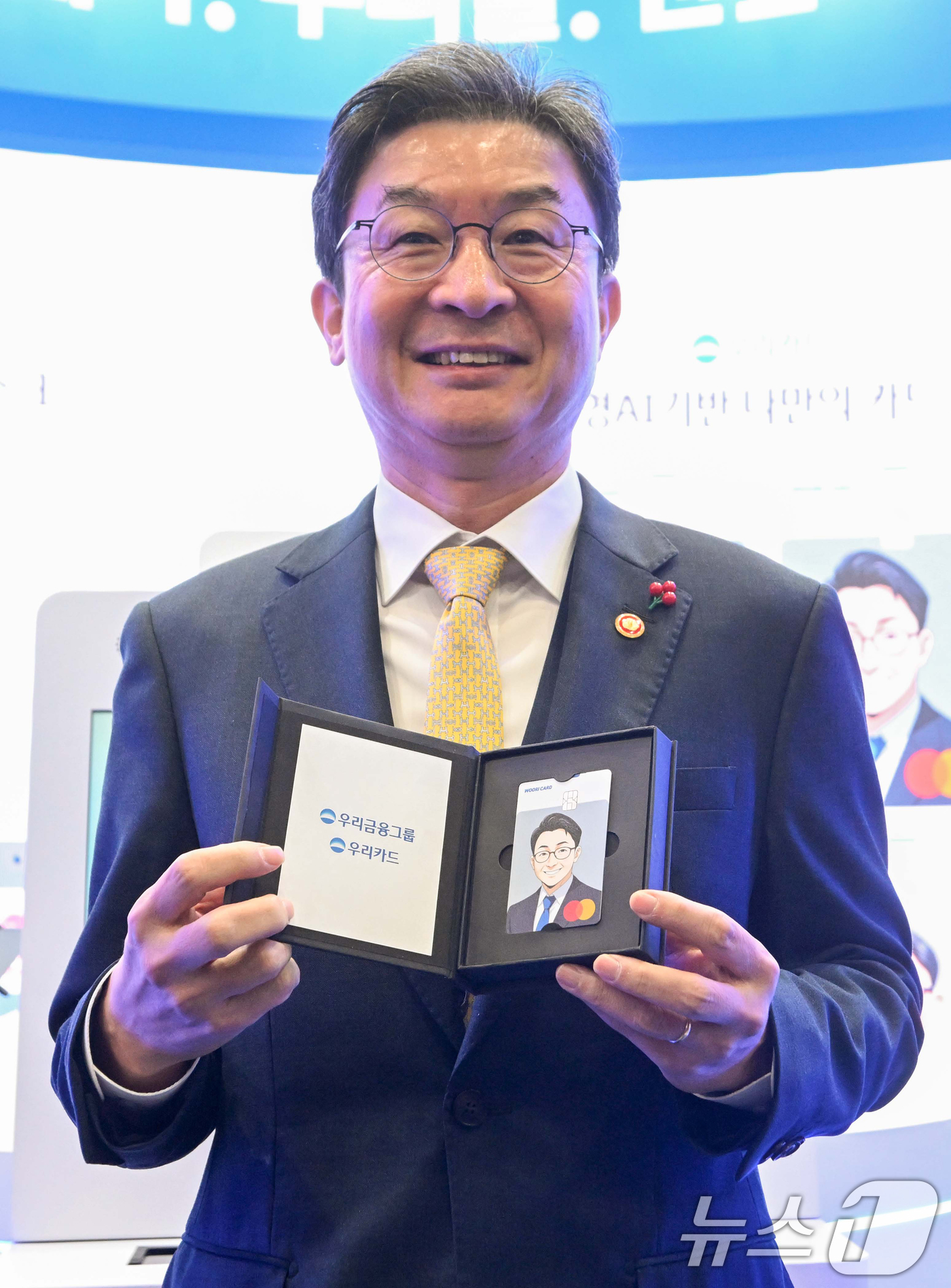 (서울=뉴스1) 오대일 기자 = 이억원 금융위원장이 26일 서울 서초구 aT센터에서 열린 코리아핀테크위크 2025 우리금융그룹 부스에서 인공지능(AI) 키오스크로 제작한 카드를 들 …