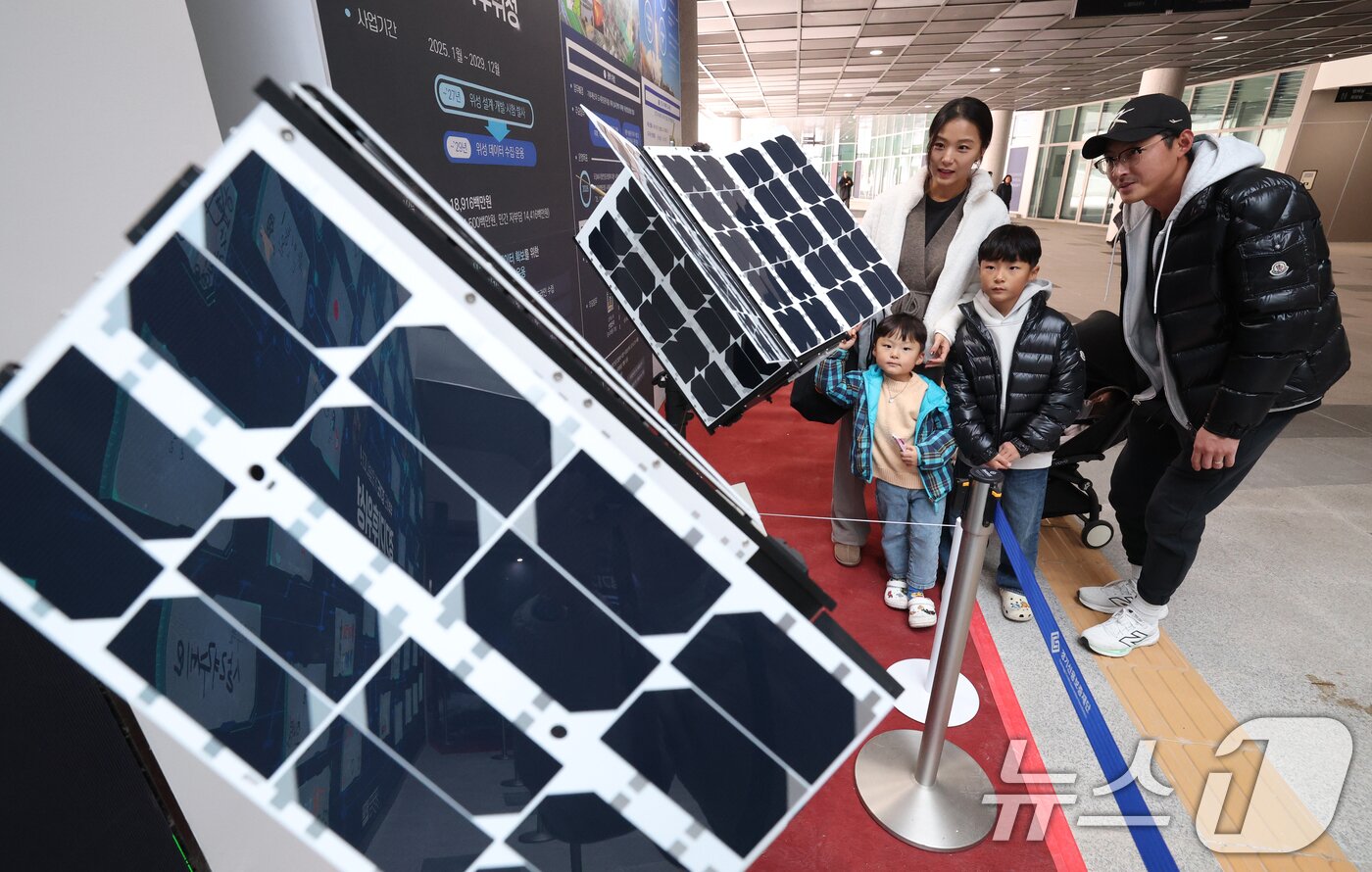 본문 이미지 - ‘경기기후위성’ 1호기 발사를 하루 앞둔 25일 경기 수원시 영통구 경기신용보증재단 도민쉼터에 마련된 경기기후위성 임시상황실에서 시민들이 &#39;경기기후위성&#39; 모형을 살펴보고 있다. ⓒ News1 김영운 기자