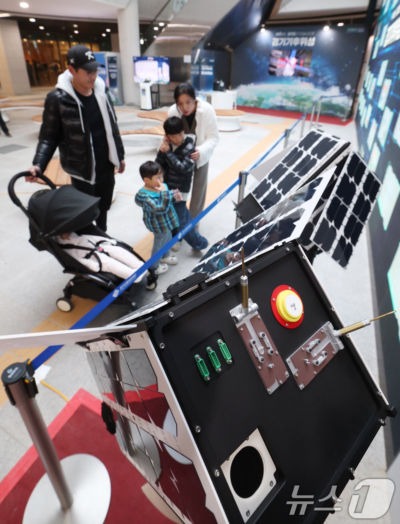 본문 이미지 - ‘경기기후위성’ 1호기 발사를 하루 앞둔 25일 경기 수원시 영통구 경기신용보증재단 도민쉼터에 마련된 경기기후위성 임시상황실에서 시민들이 &#39;경기기후위성&#39; 모형을 살펴보고 있다. ⓒ News1 김영운 기자