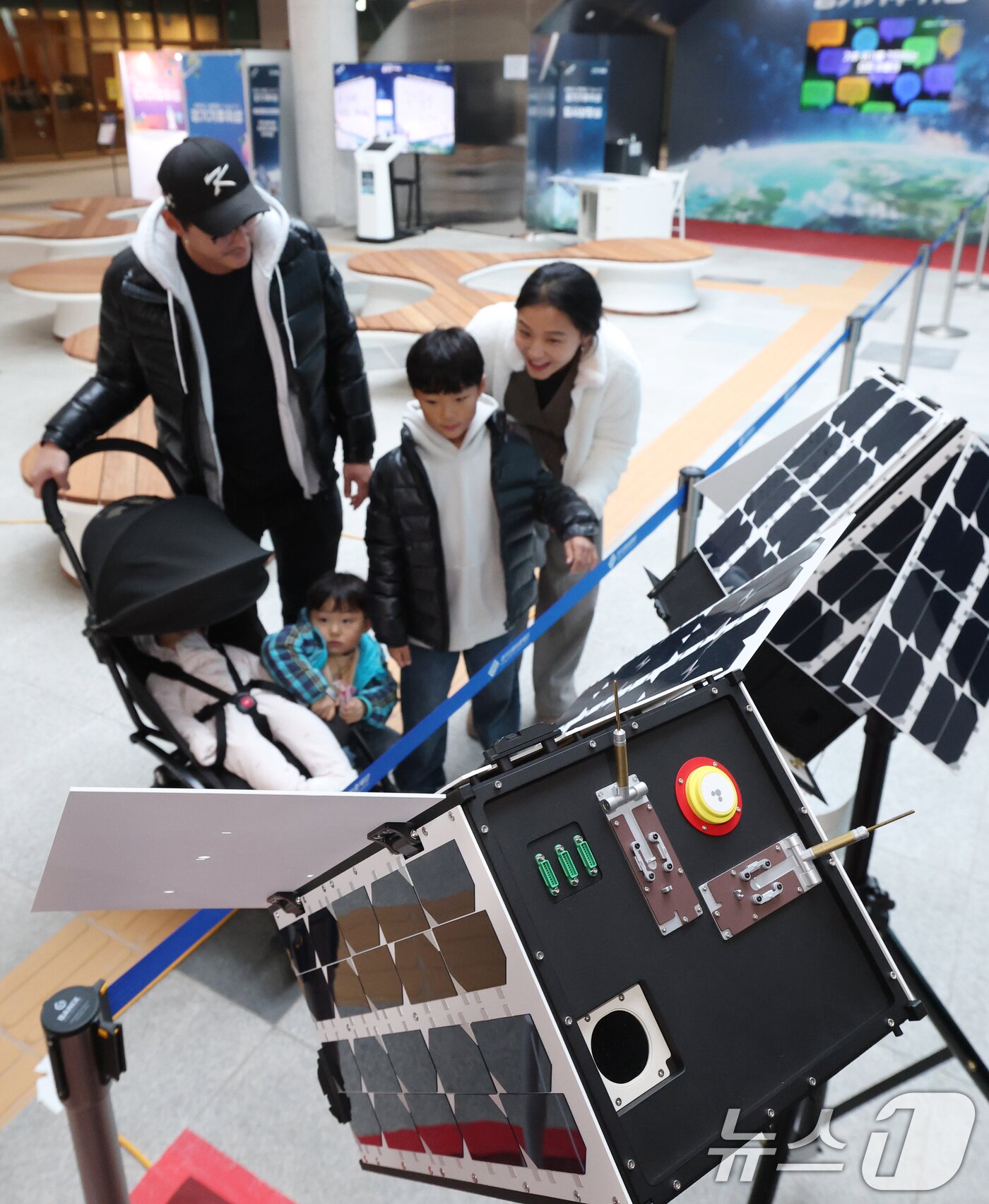 본문 이미지 - ‘경기기후위성’ 1호기 발사를 하루 앞둔 25일 경기 수원시 영통구 경기신용보증재단 도민쉼터에 마련된 경기기후위성 임시상황실에서 시민들이 &#39;경기기후위성&#39; 모형을 살펴보고 있다. ⓒ News1 김영운 기자