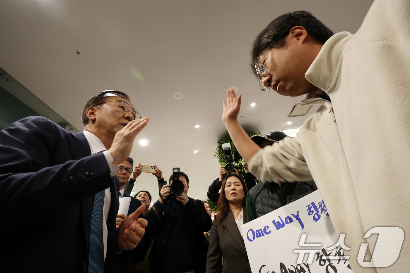 (무안=뉴스1) 박지현 기자 = 김윤덕 국토교통부 장관이 26일 전남 무안군 무안국제공항에서 열린 공청회장 앞에서 12·29 제주항공 참사 유가족협의회의 항의를 받고 있다, 김 장 …