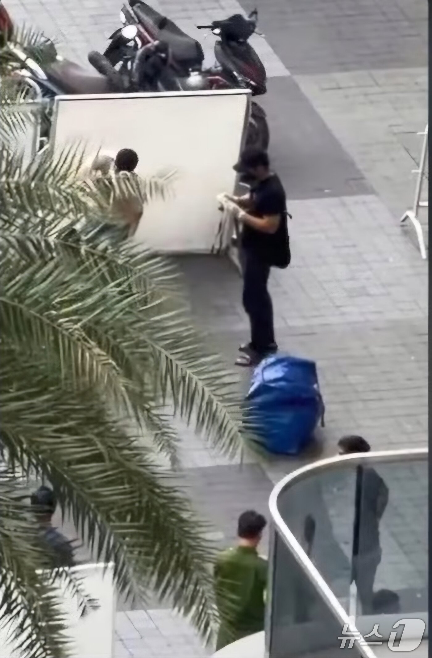 본문 이미지 - 시신이 담긴 가방을 호찌민 한 아파트 입구에 버리고 용의자들이 도주했다.(베트남 플러스 제공. 재판매 및 DB 금지)2025.11.26/뉴스1