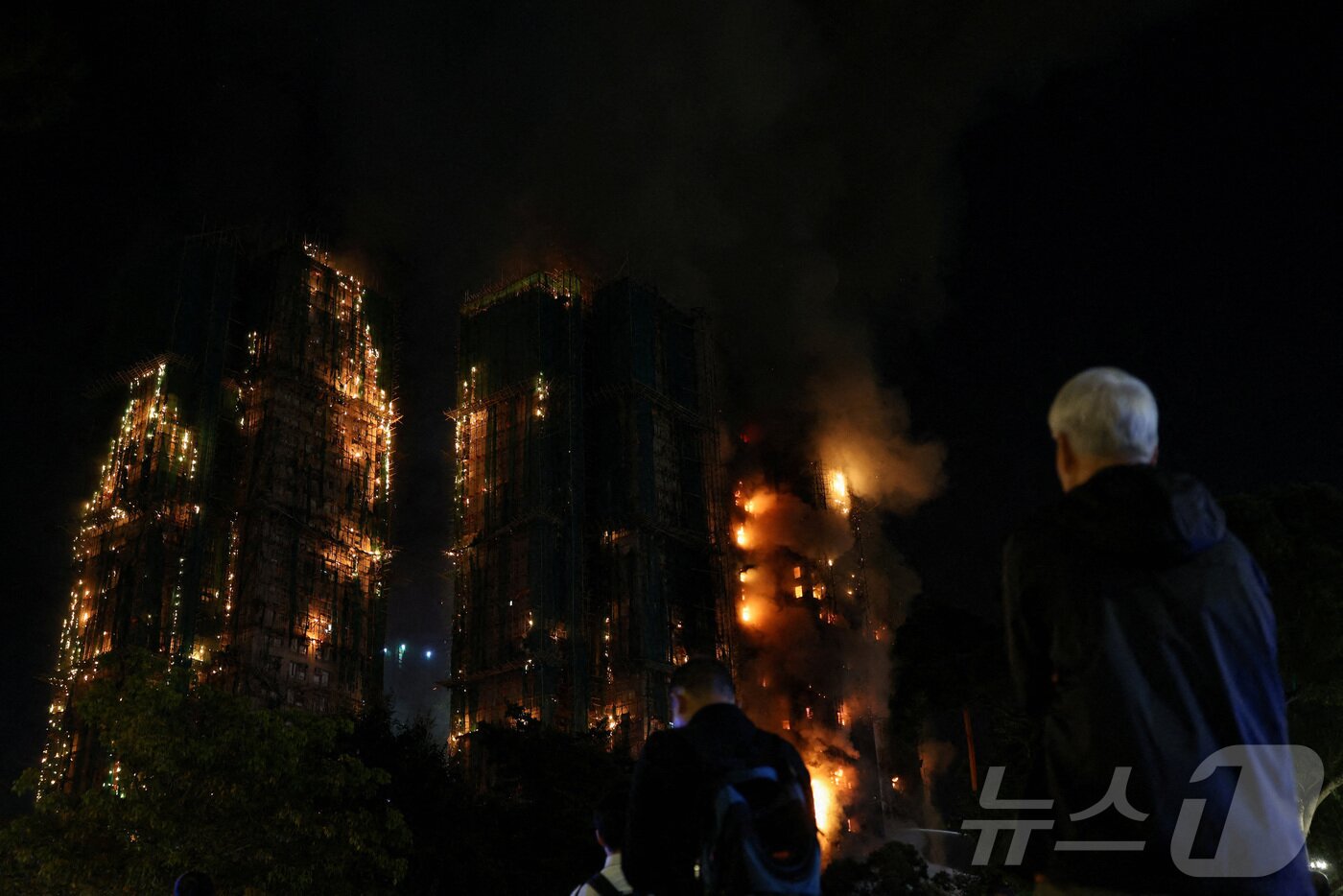 본문 이미지 - 26일&#40;현지시간&#41; 중국 홍콩 타이포의 &#39;왕 훅 코트&#39; 주택 단지에서 주민들이 불타는 대나무 비계를 바라보고 있다. 2025.11.26. ⓒ 로이터=뉴스1 ⓒ News1 윤다정 기자