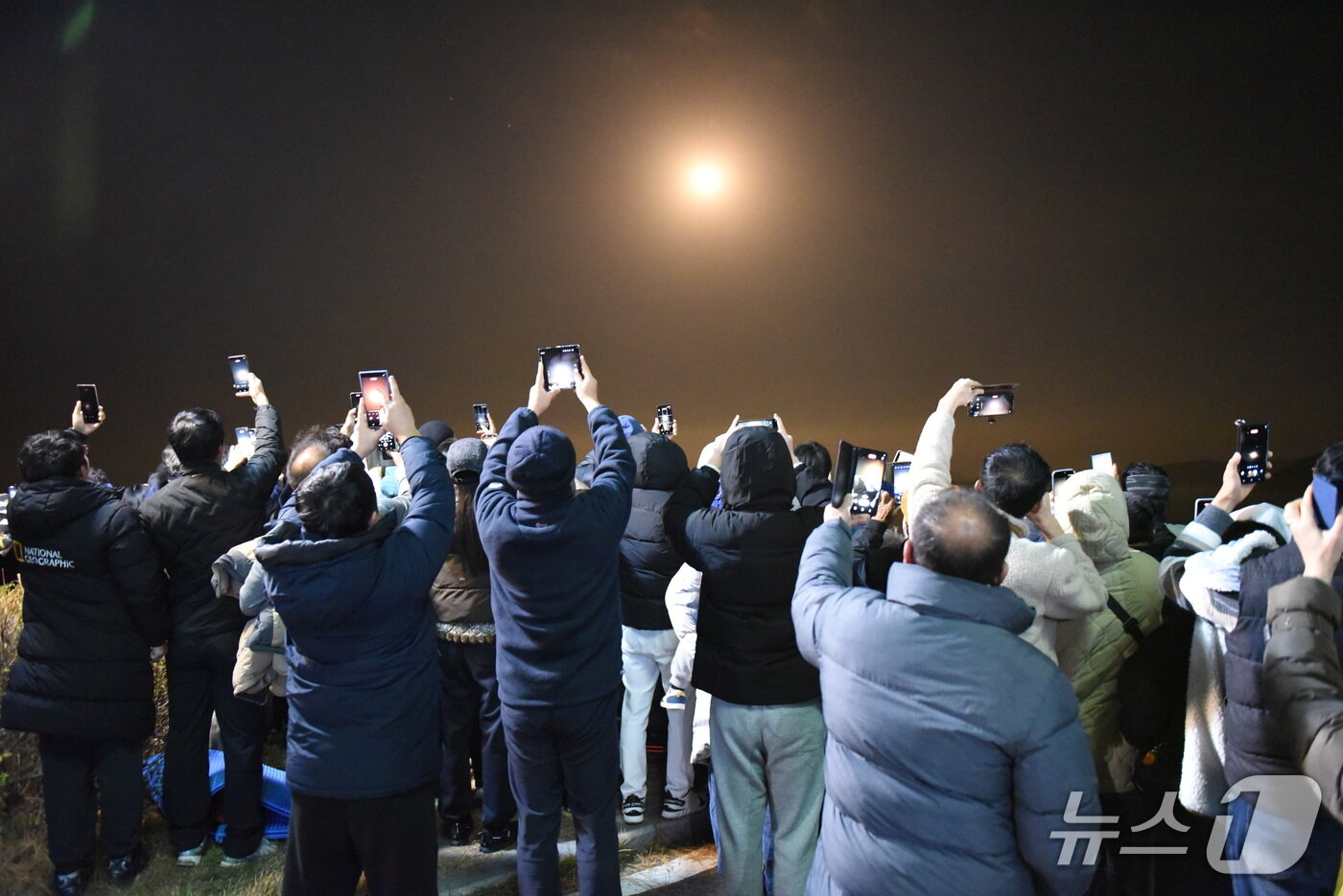 본문 이미지 - 27일 누리호가 발사되자 고흥우주발사전망대에서 바라보던 관람객들이 동영상을 촬영하고 있다.