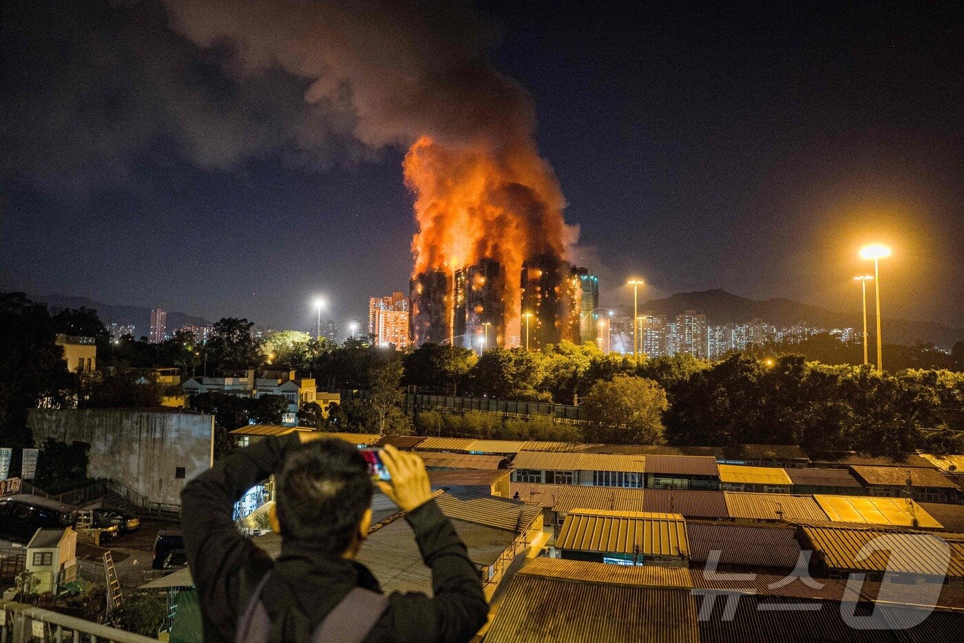 본문 이미지 - 26일 발생한 홍콩 왕쿡 코트 아파트 화재 현장, 한 시민이 화재 현장을 카메라에 담고 있다. ⓒ AFP=뉴스1 ⓒ News1 박형기 기자