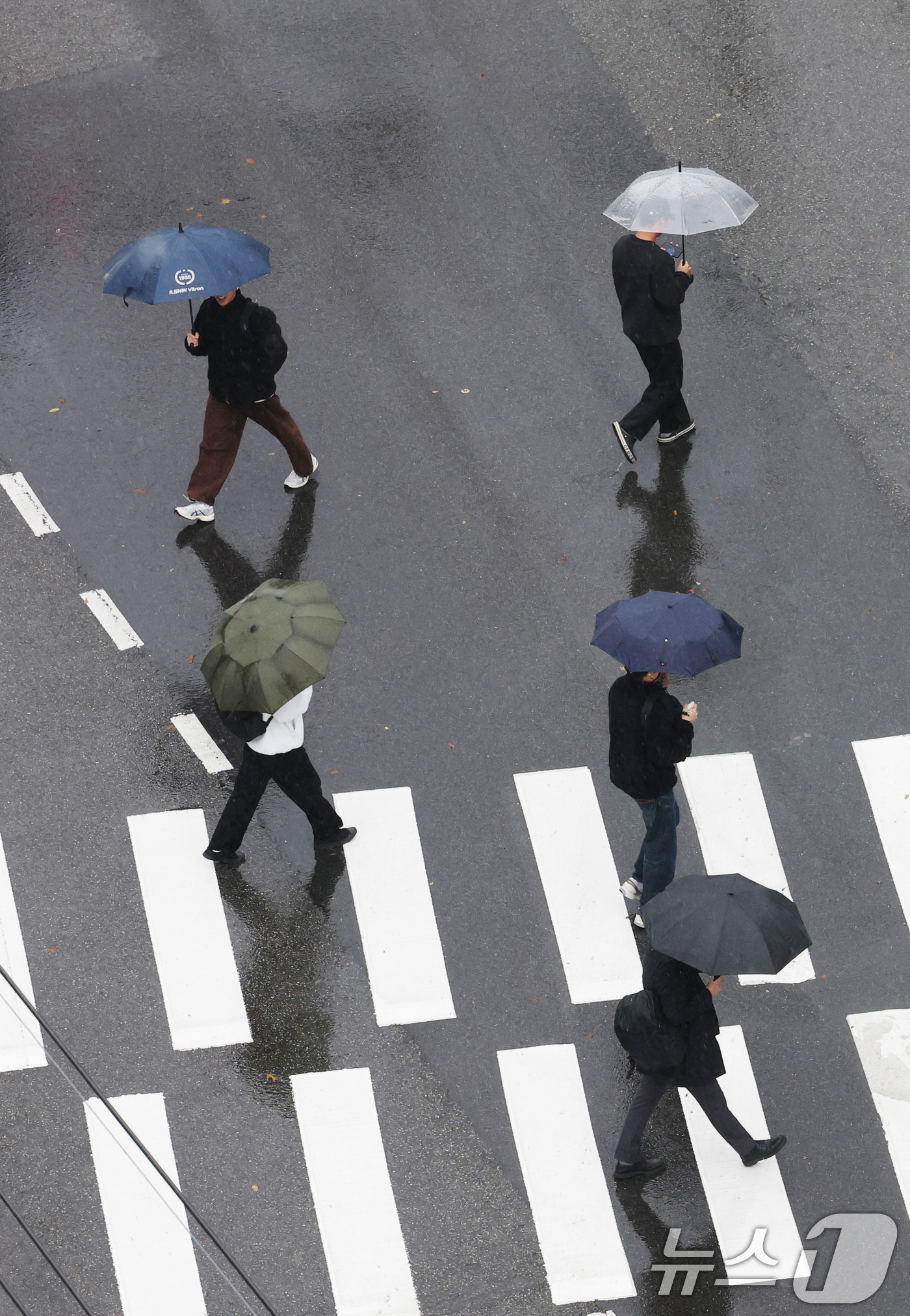 (수원=뉴스1) 김영운 기자 = 전국이 대체로 흐리고 비가 내린 27일 경기 수원시 영통구 아주대학교 근처에서 시민들과 학생들이 우산을 쓰고 지나가고 있다. 2025.11.27/뉴 …