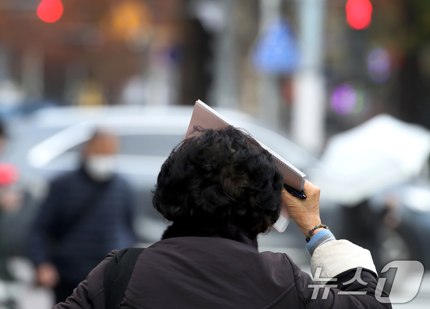 (대구=뉴스1) 공정식 기자 = 27일 오후 비가 내리는 대구 수성구 달구벌대로에서 우산을 준비하지 못한 시민이 소지품으로 머리를 가린 채 발걸음을 재촉하고 있다. 2025.11. …