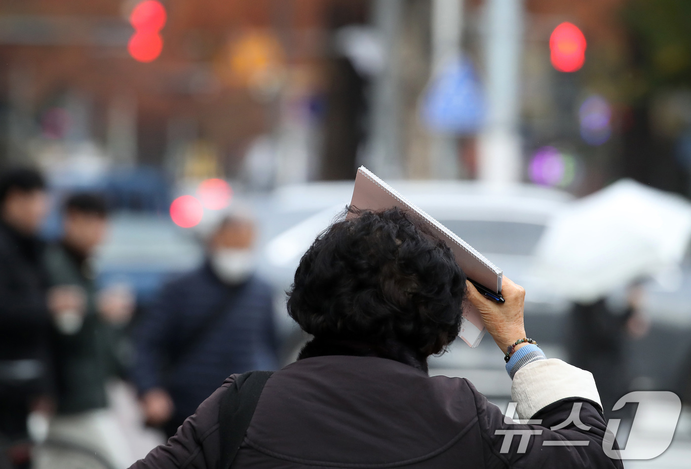 (대구=뉴스1) 공정식 기자 = 27일 오후 비가 내리는 대구 수성구 달구벌대로에서 우산을 준비하지 못한 시민이 소지품으로 머리를 가린 채 발걸음을 재촉하고 있다. 2025.11. …