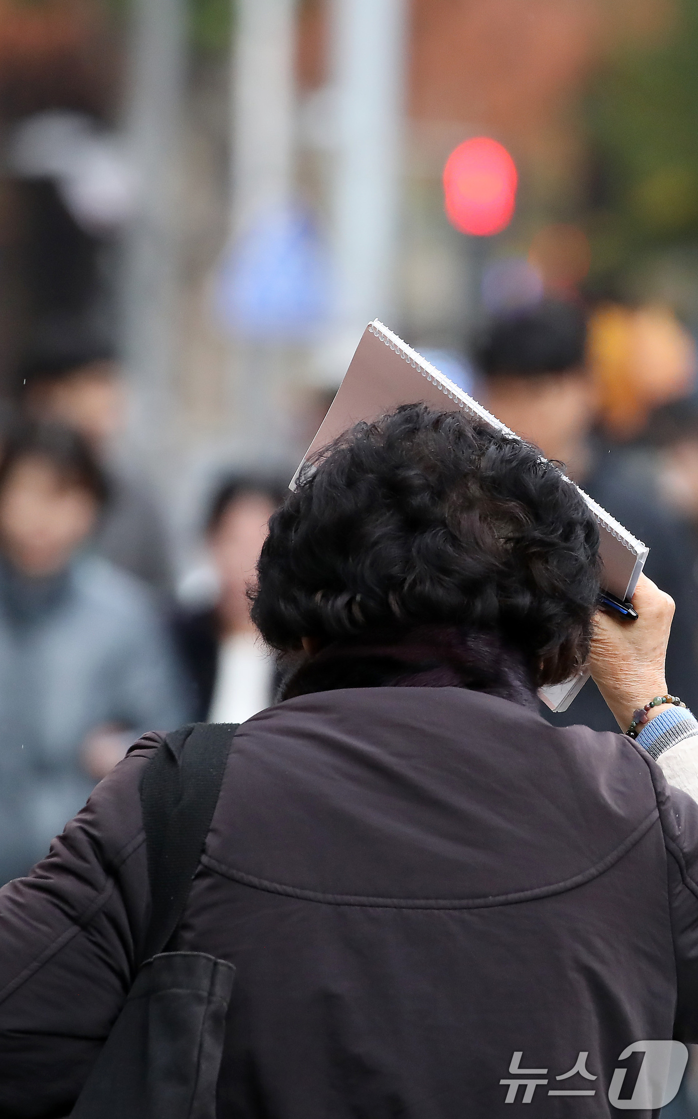 (대구=뉴스1) 공정식 기자 = 27일 오후 비가 내리는 대구 수성구 달구벌대로에서 우산을 준비하지 못한 시민이 소지품으로 머리를 가린 채 발걸음을 재촉하고 있다. 2025.11. …